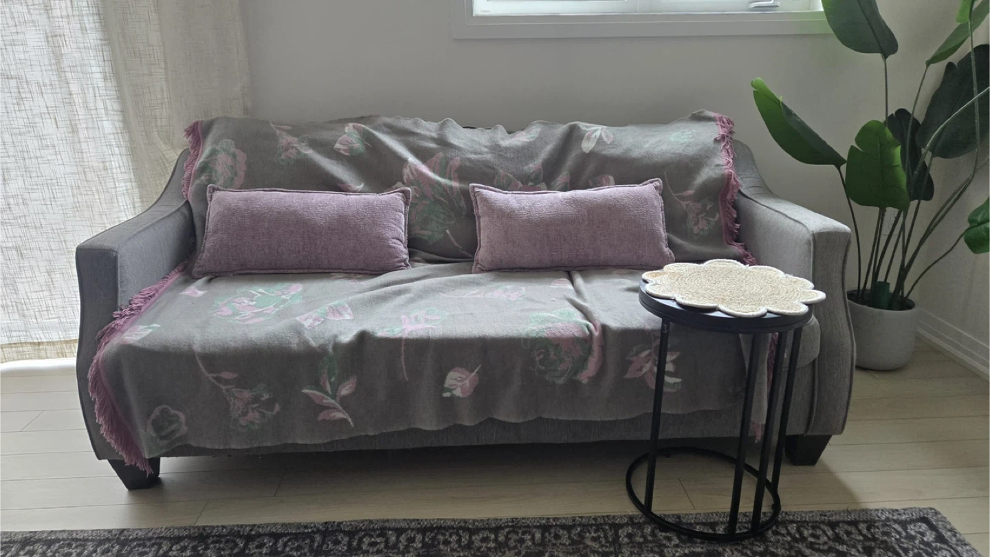 Grey Three-Seater Sofa with Throw Blanket