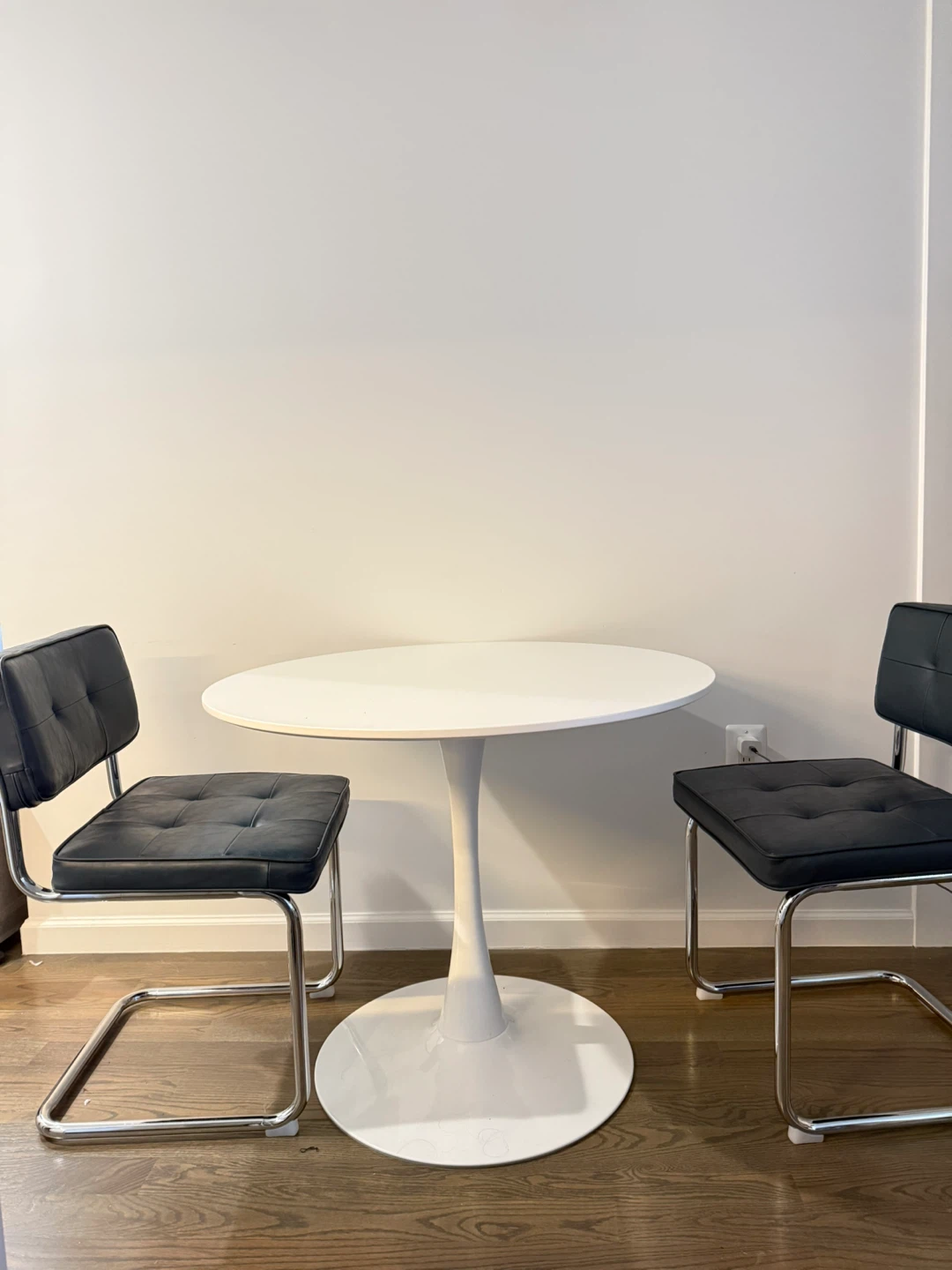 White Round Tulip Dining Table with 2 Black Chairs