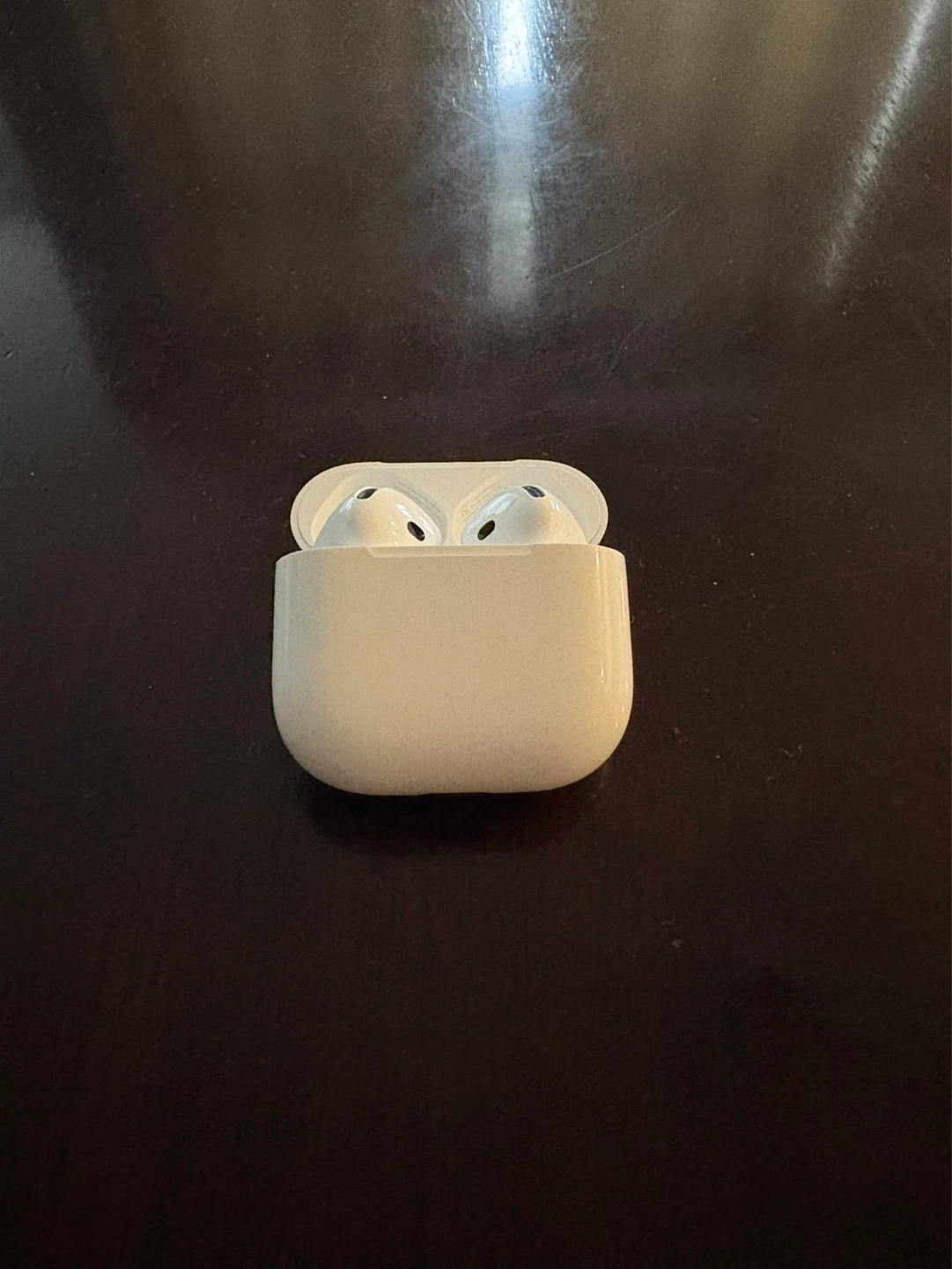 Airpods 4 with Charging Case, white power adapter and Charger.