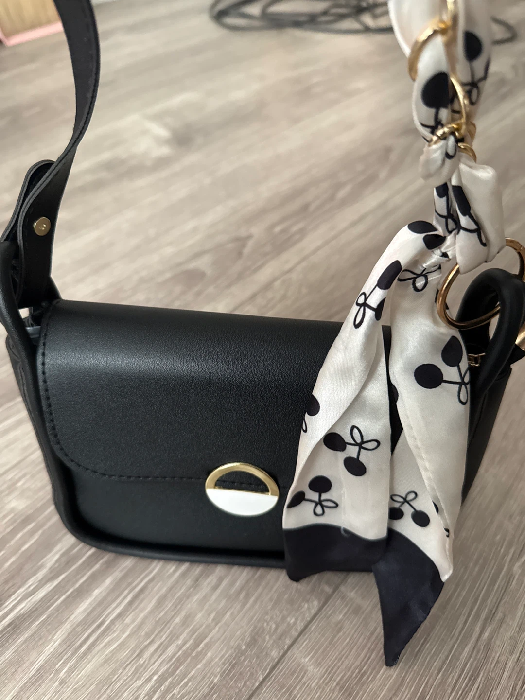Black handbag with cherry scarf accent