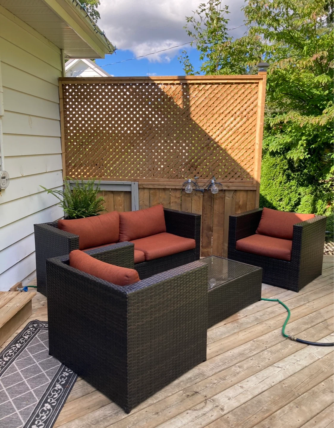 Rattan patio furniture set with orange cushions