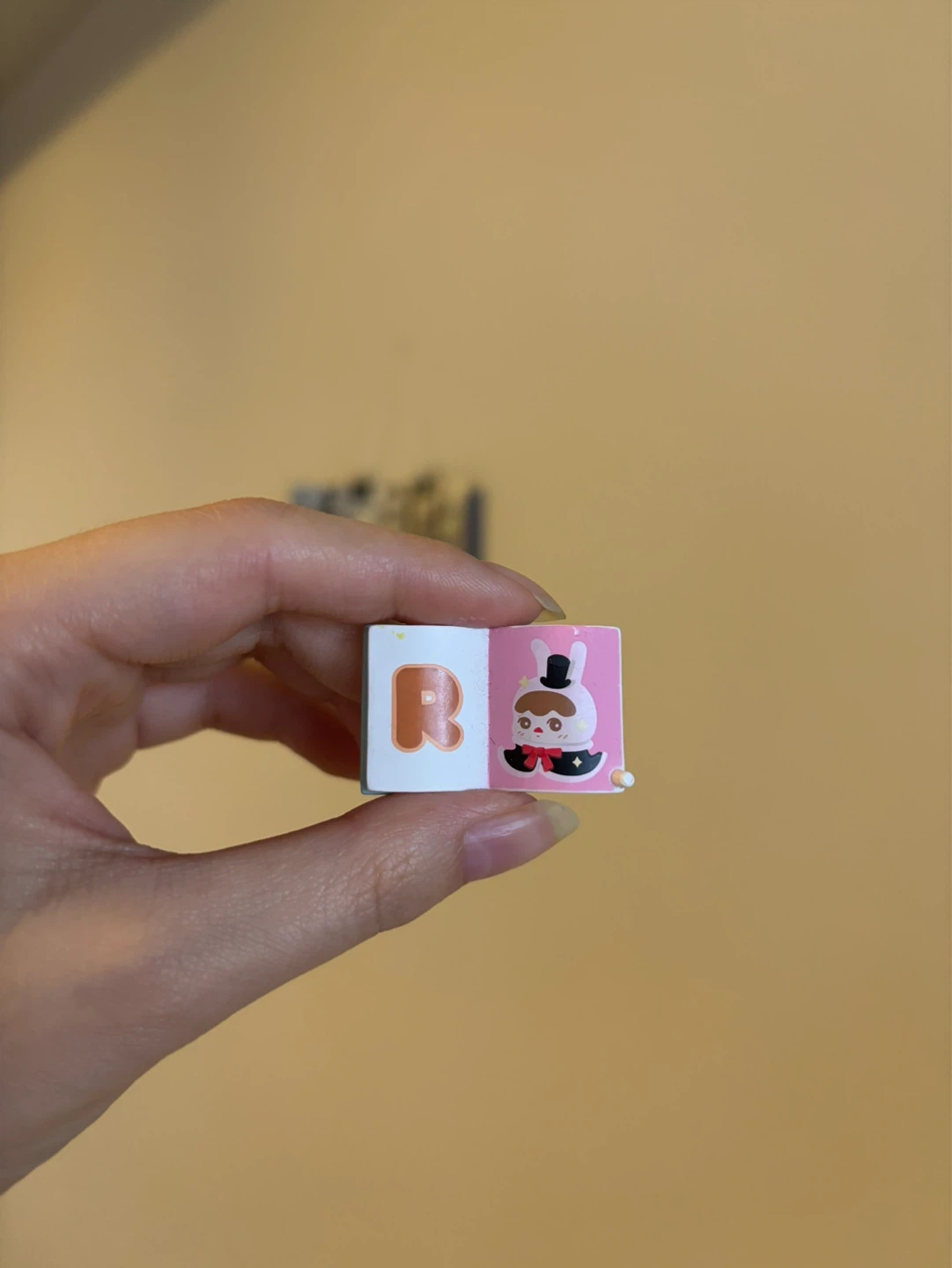 Miniature book with 'R' and character