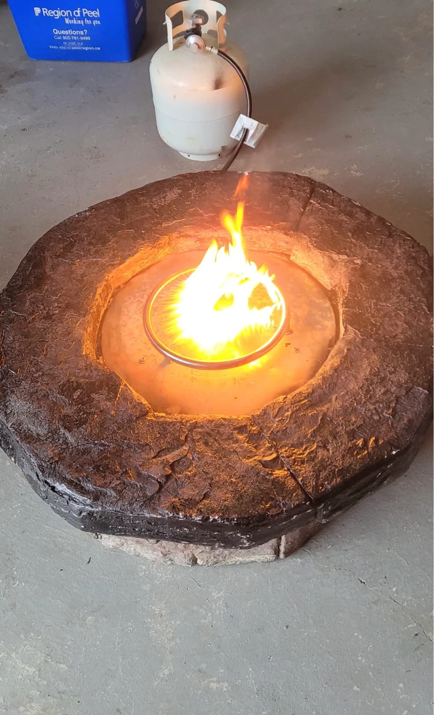 Propane fire pit with stone-look surround