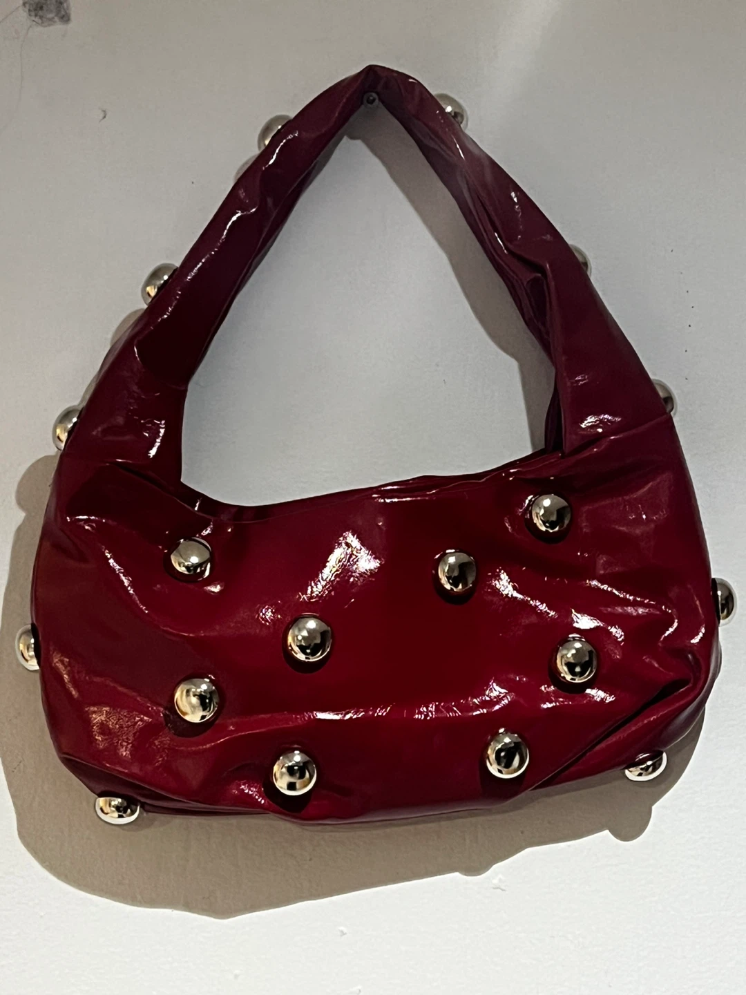 Red patent shoulder bag with silver studs