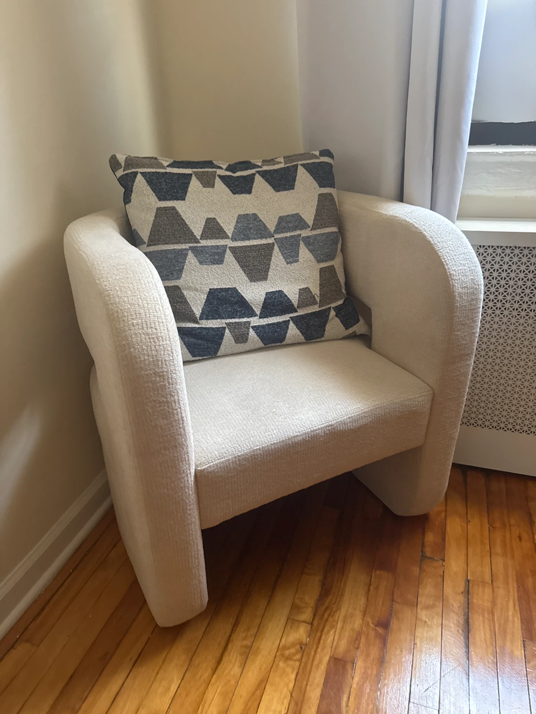 Cream Upholstered Armchair with Geometric Pillow