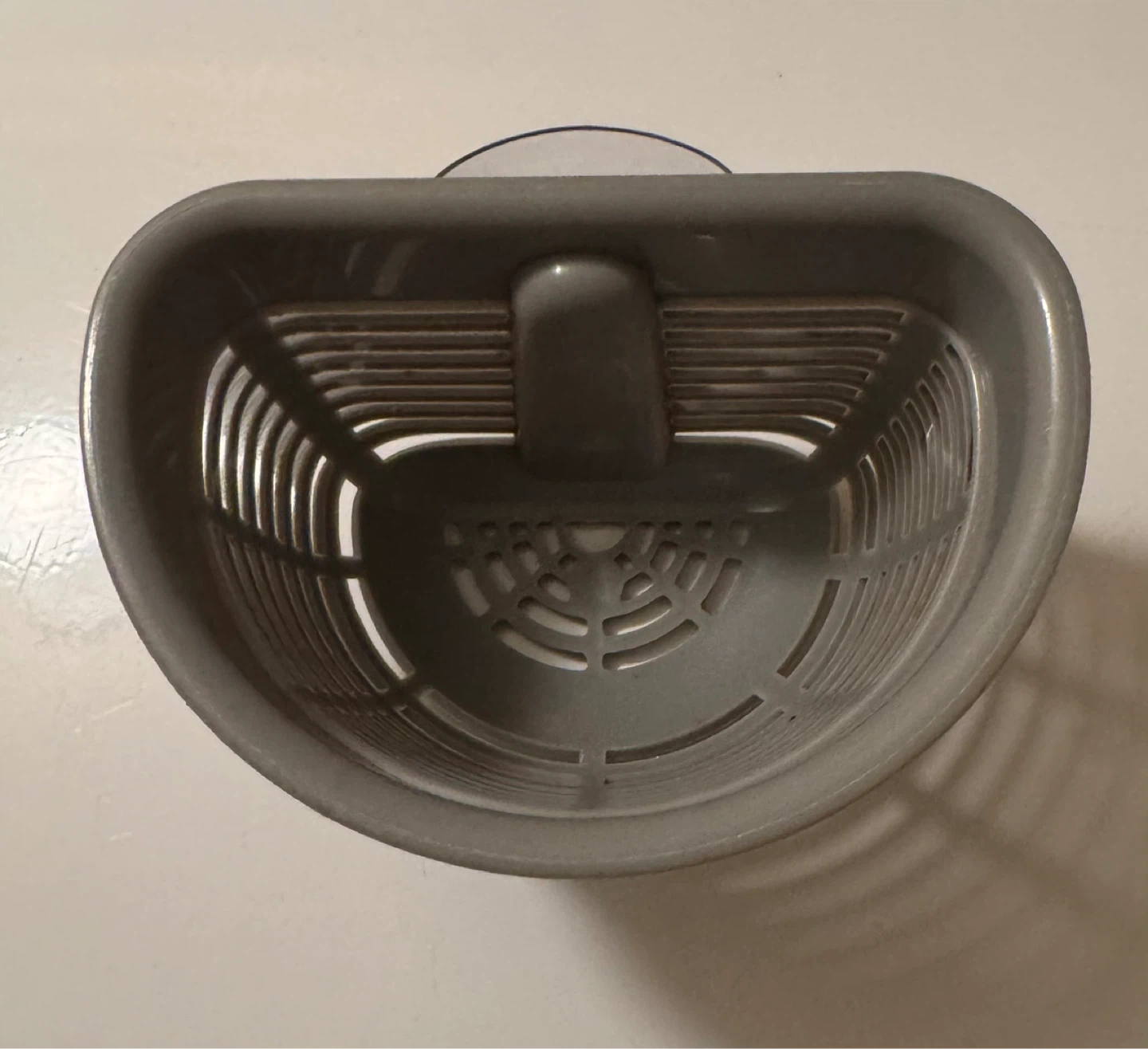 Grey plastic shower caddy with suction cup