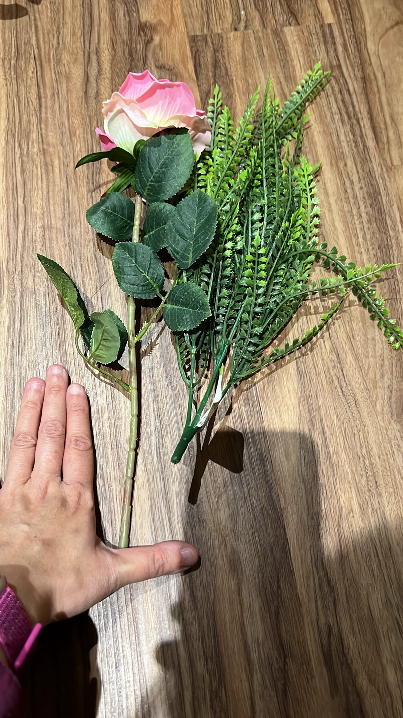 Artificial pink rose and greenery