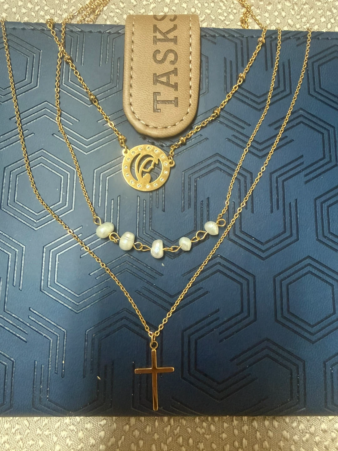 Gold tone layered necklace with cross and pearls