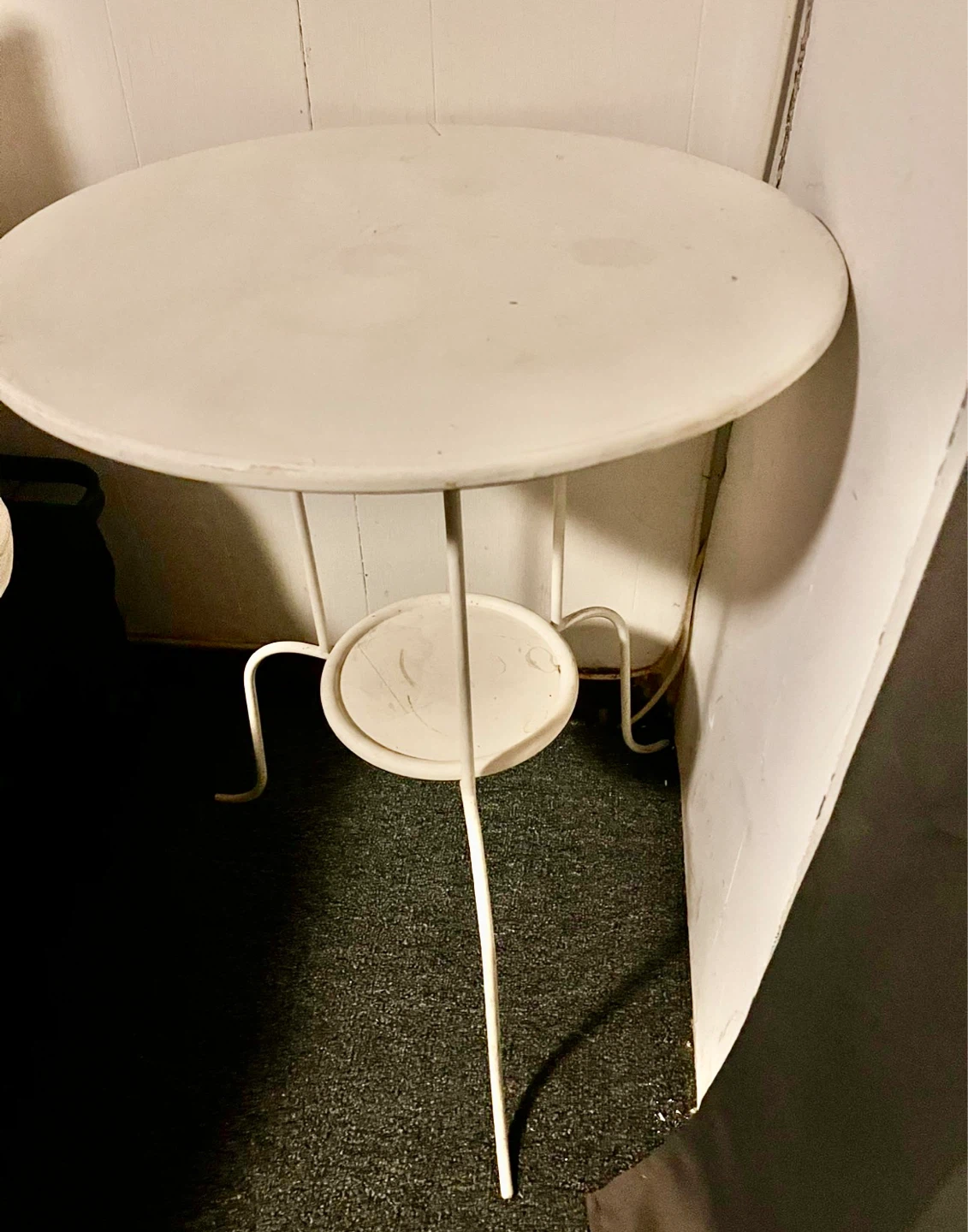 Round white metal side table with lower shelf