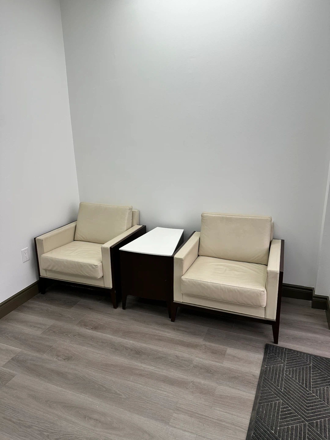 Two cream leather accent chairs with dark wood frames