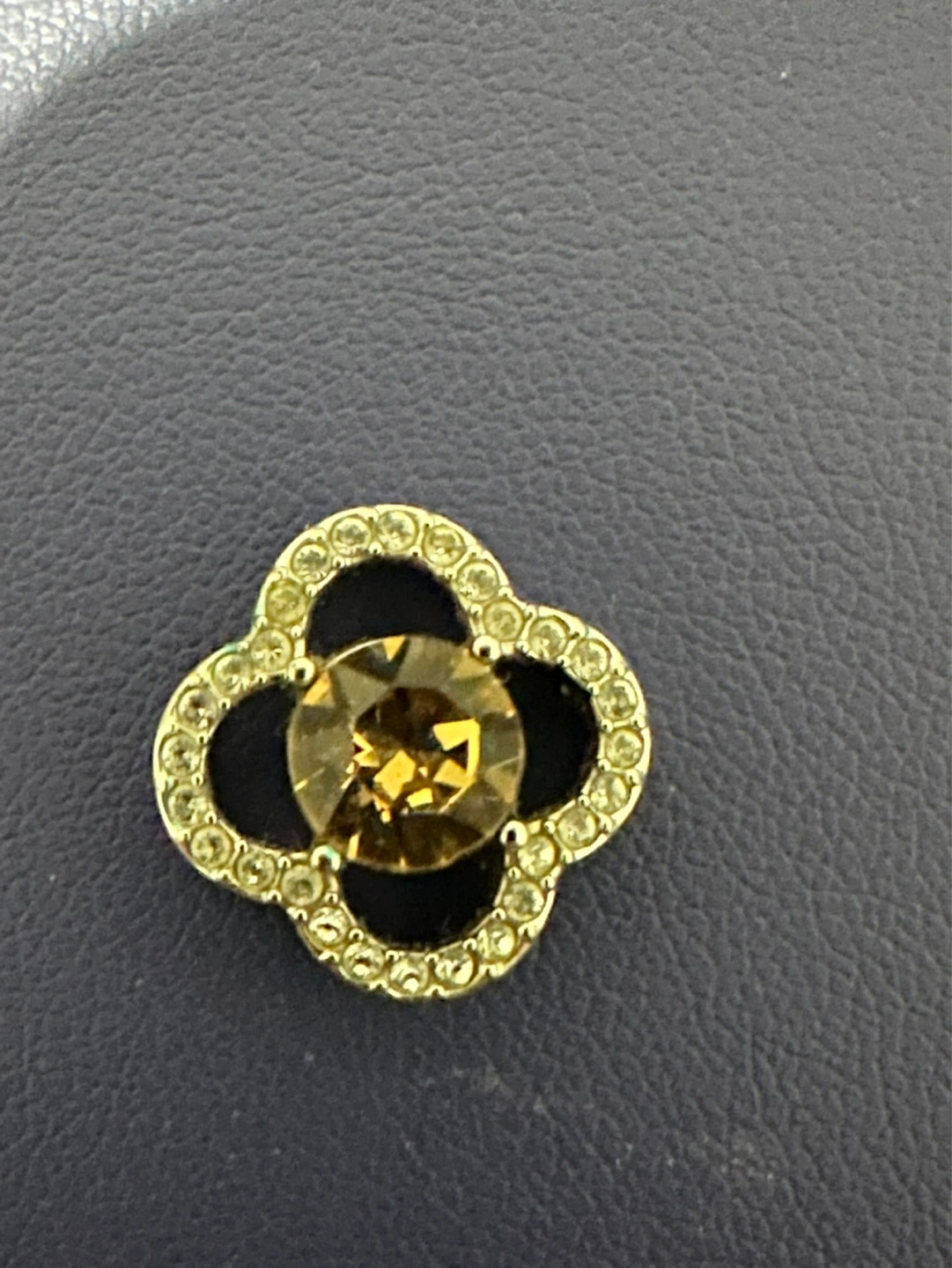 Silver tone clover charm with amber-coloured stone