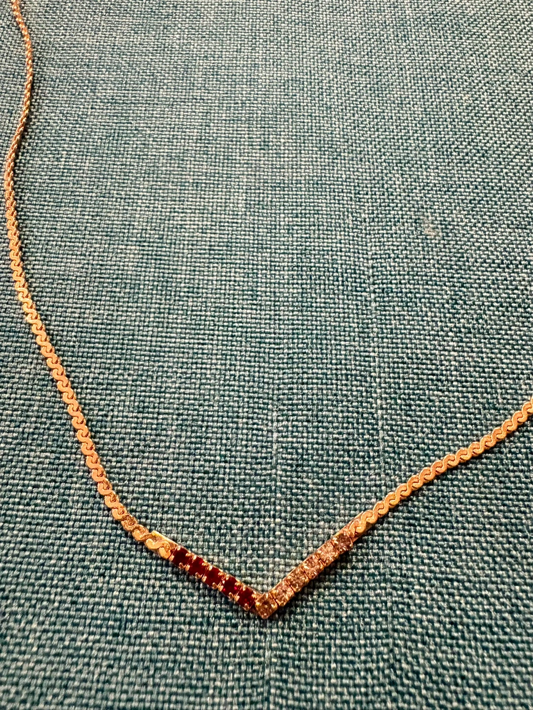 Gold-tone V-shape necklace with red and clear stones