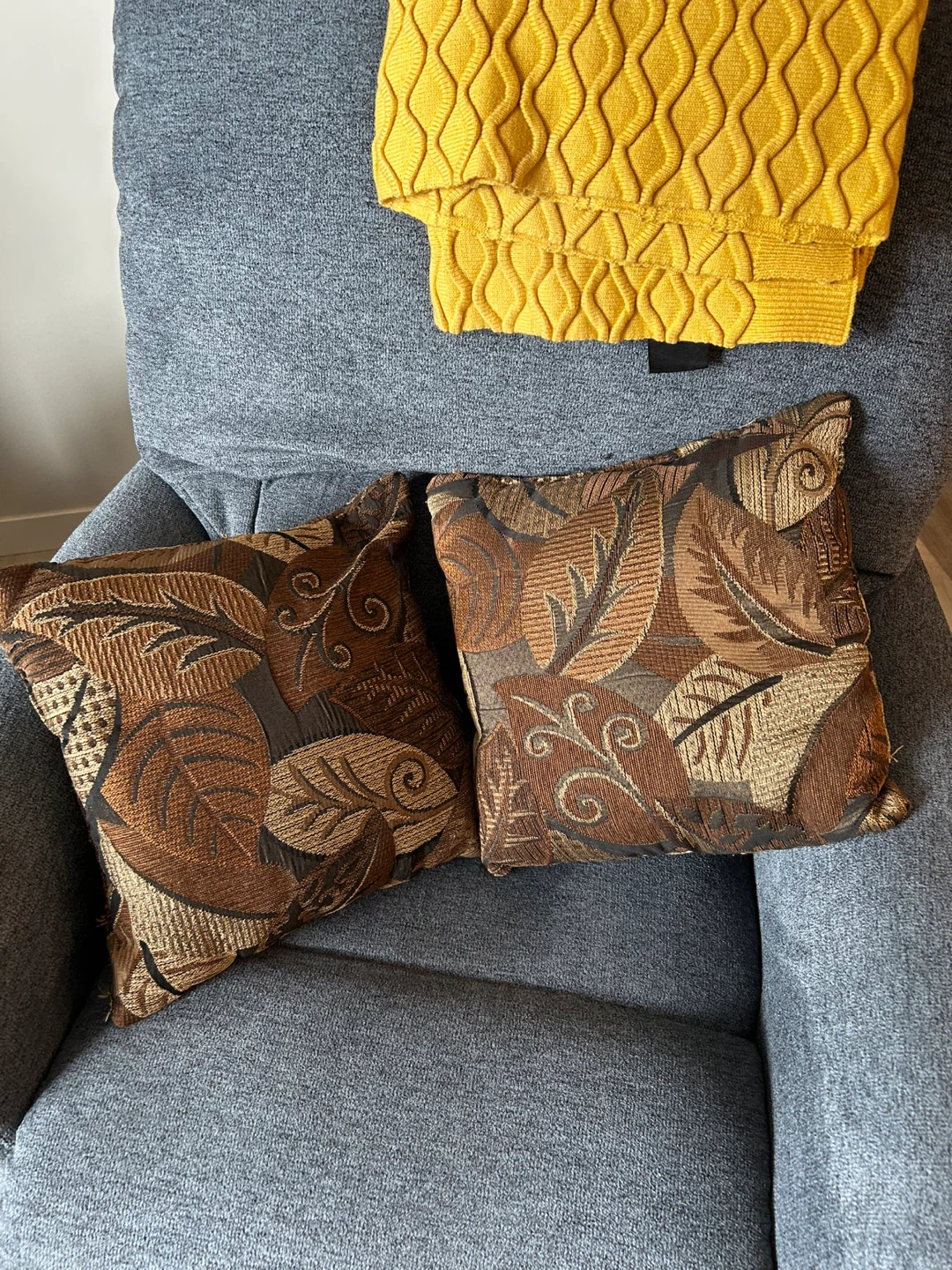 Two decorative throw pillows with leaf pattern