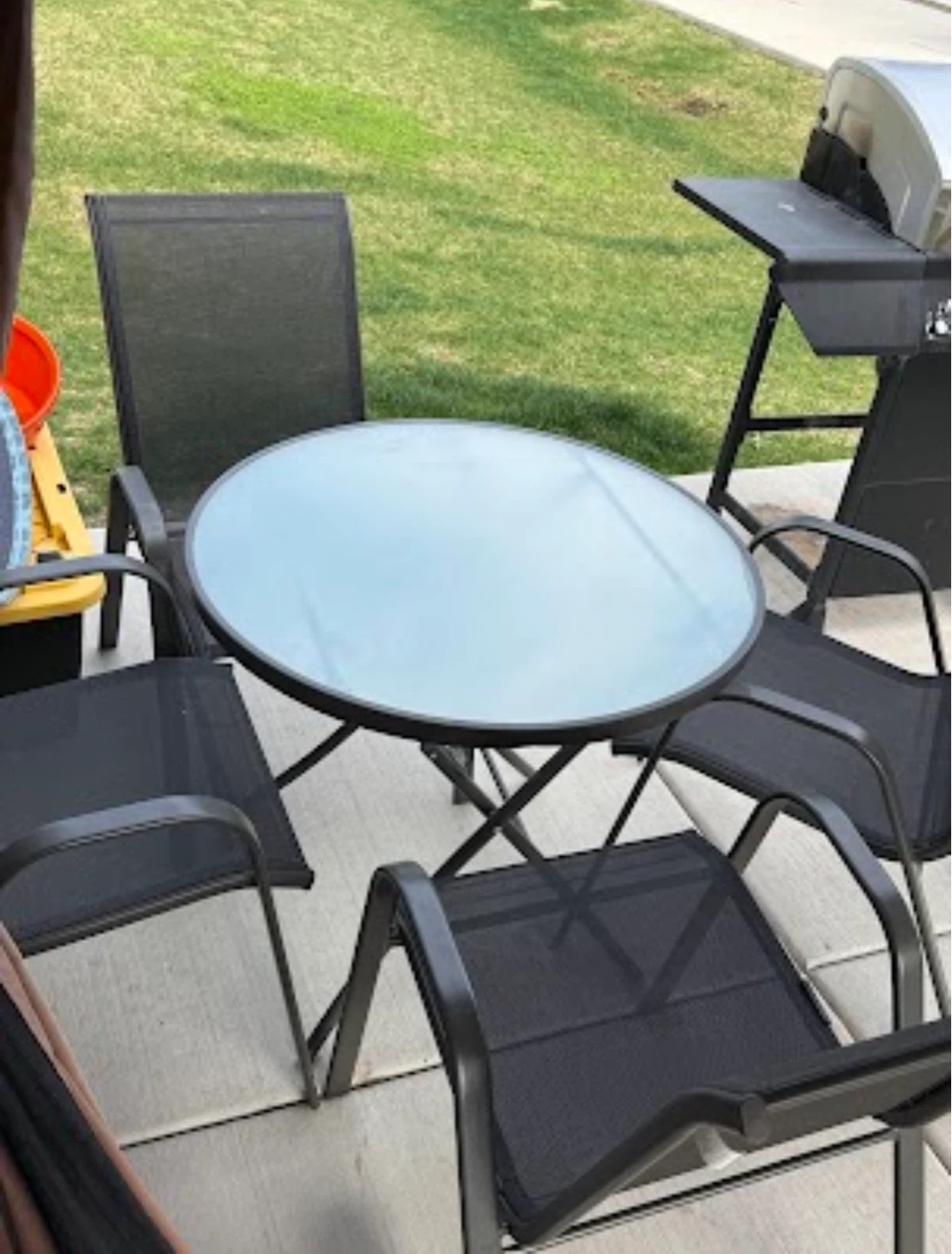 Round Glass Top Patio Table with 4 Black Mesh Chairs