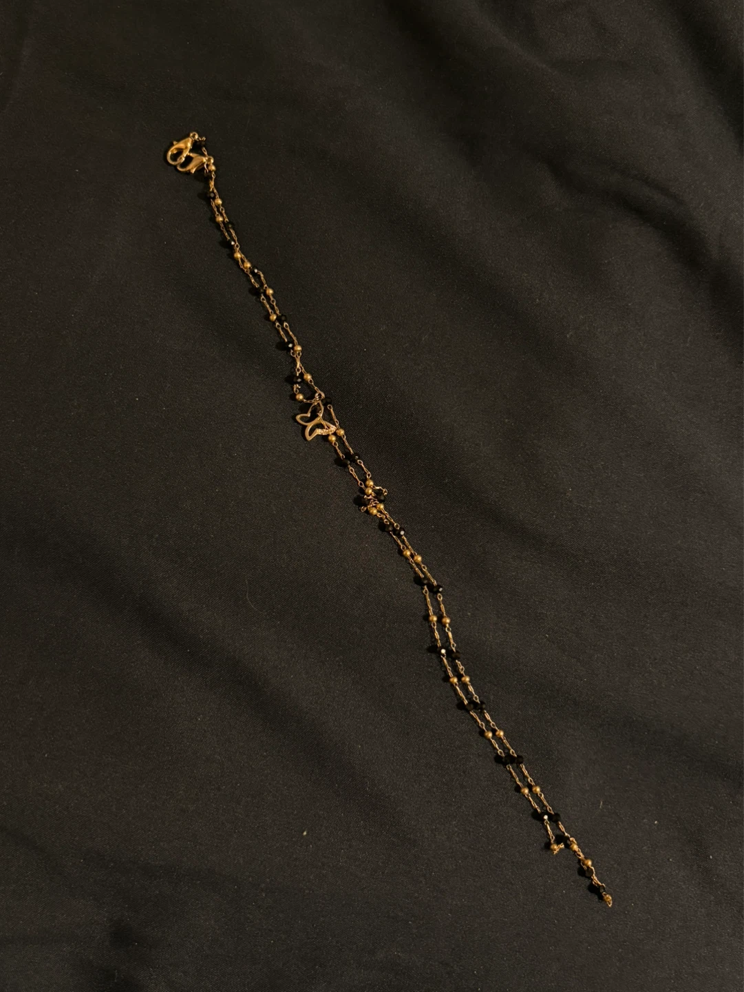 Gold-tone long anklet with black beads and butterfly charm