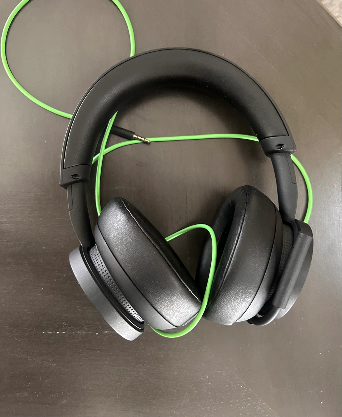 Black over-ear headphones with green cable