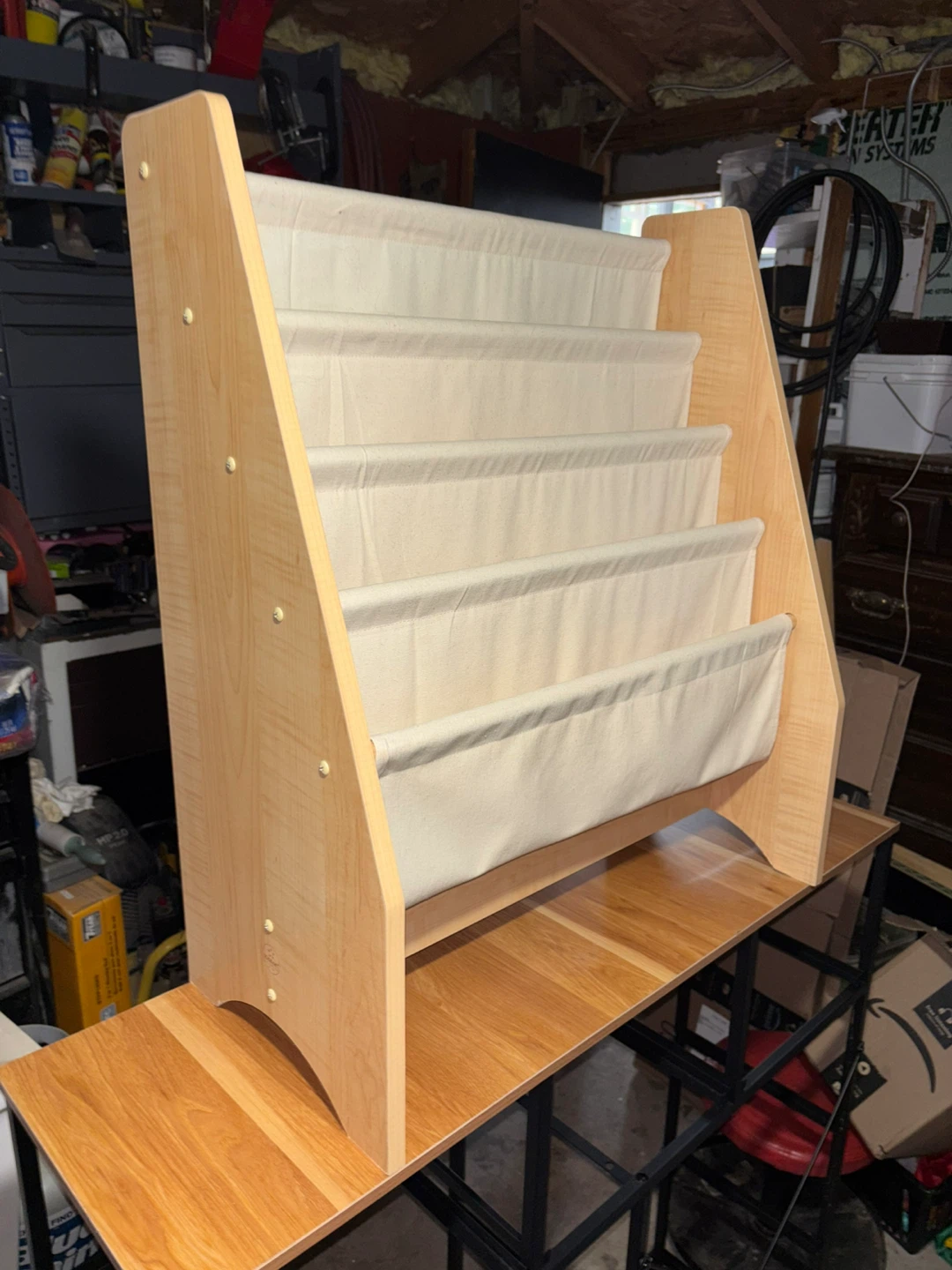 This wooden bookshelf features fabric pockets