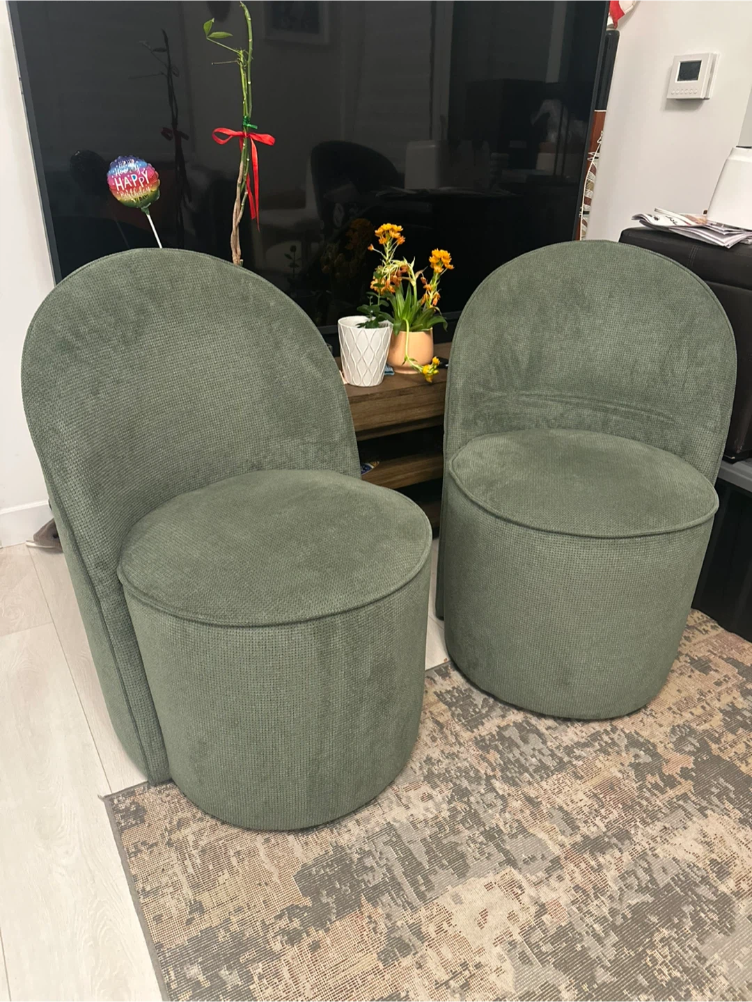 Pair of green accent chairs with wheels