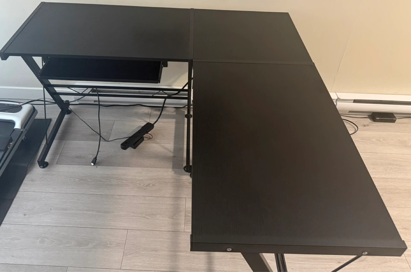 Black L-shaped desk with keyboard tray