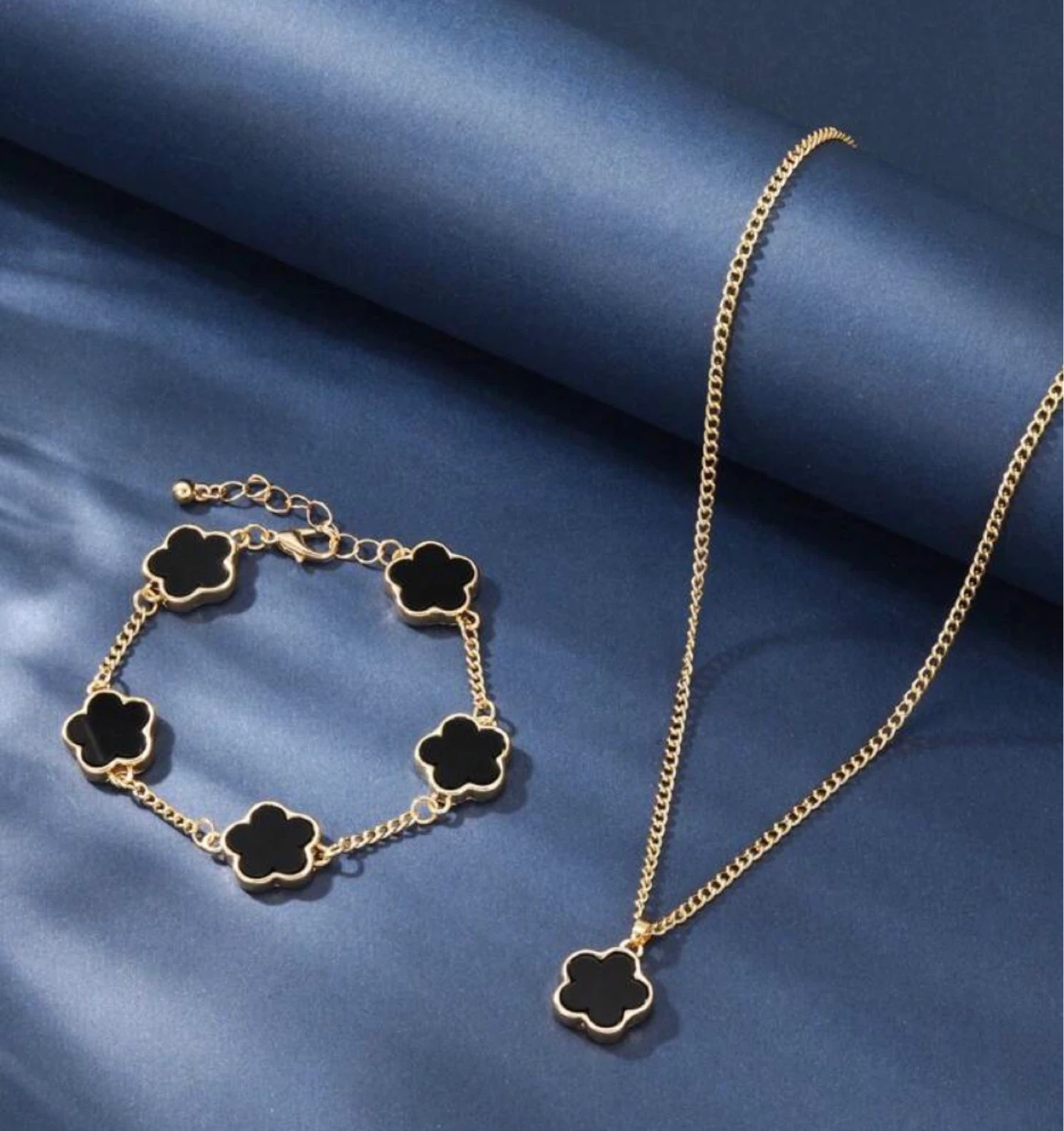 Gold-tone necklace and bracelet set with black clover charms