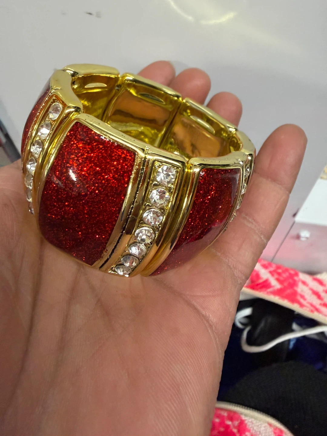 Gold tone stretchy bracelet with red glitter and rhinestones