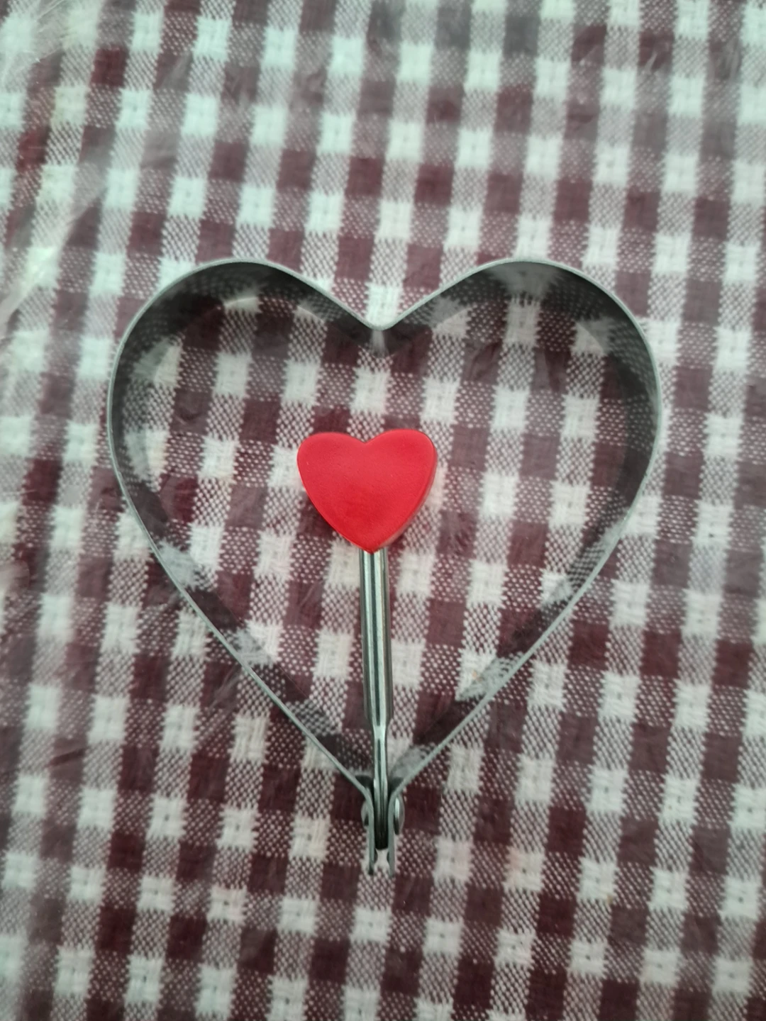 Heart-shaped cookie cutter with red handle