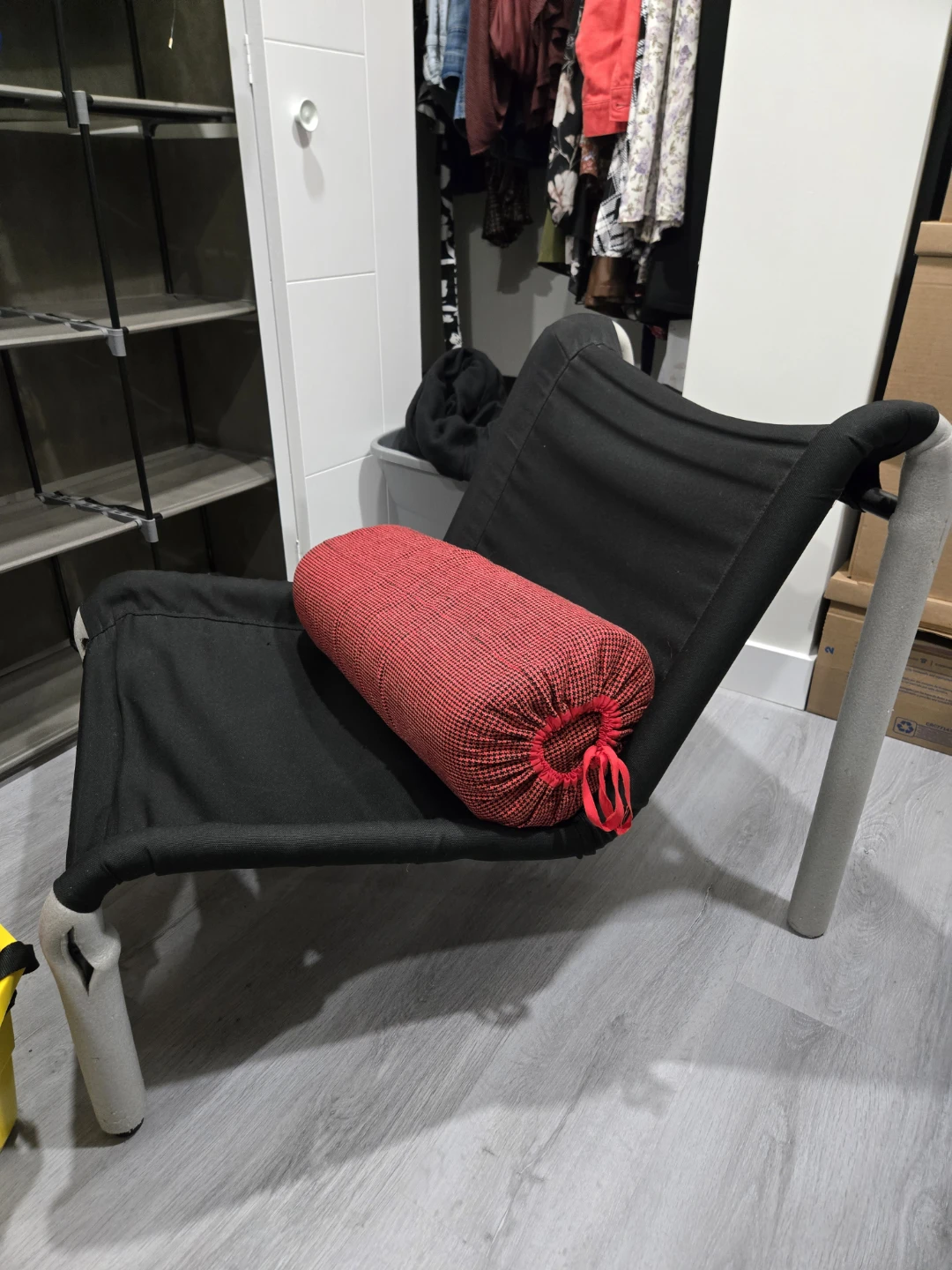 Black lounge chair with red bolster pillow