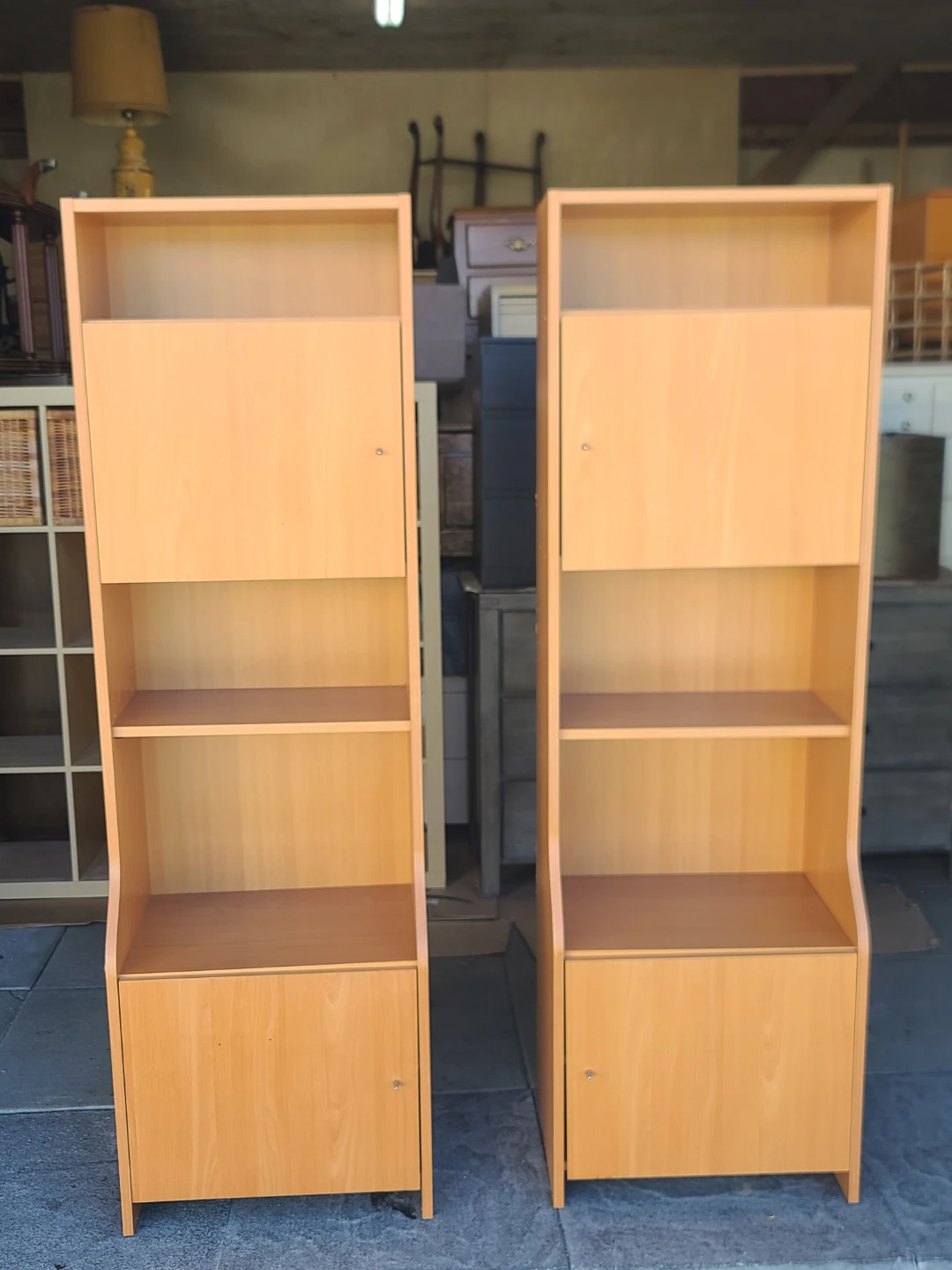 Pair of light wood bookcases with doors and shelves
