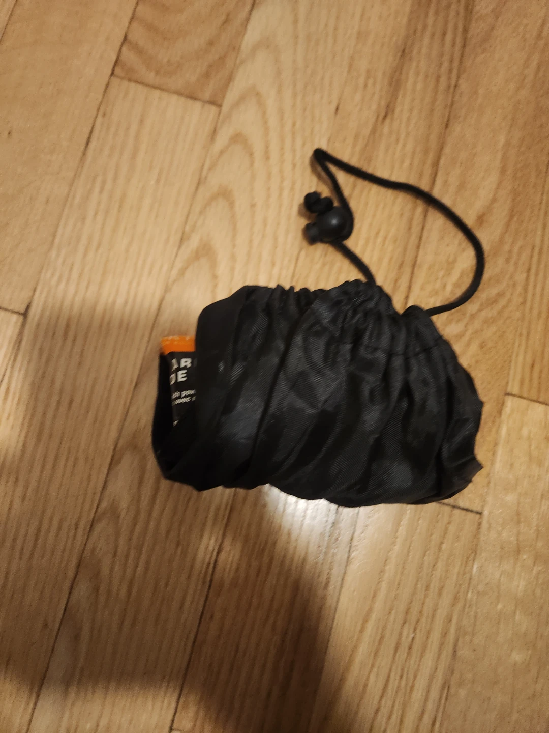 Black drawstring pouch with orange item inside