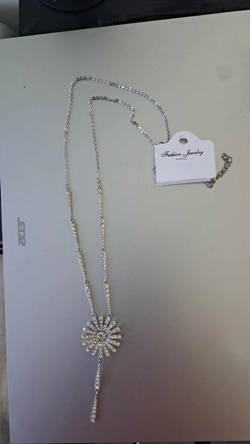 Silver tone lariat necklace with sunburst pendant