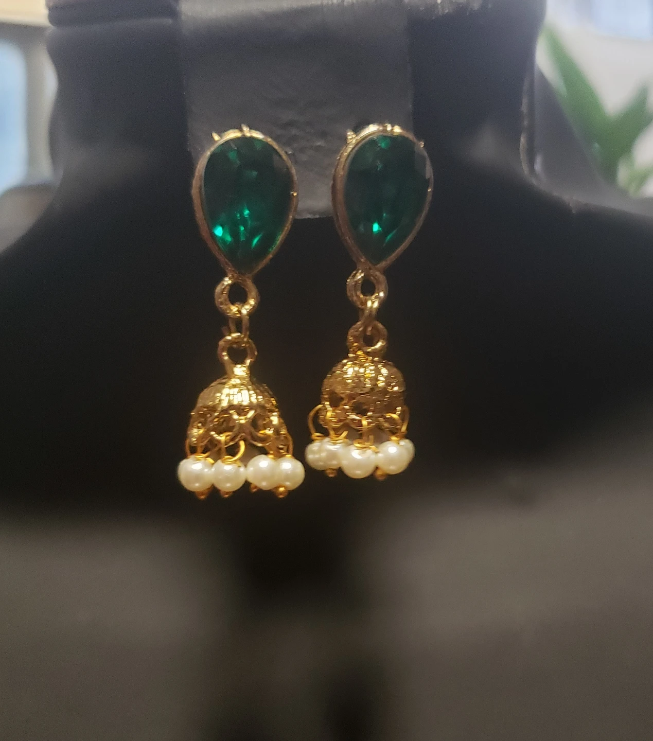 Gold coloured jhumka earrings .