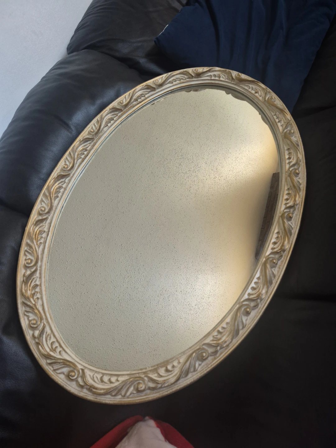 Oval decorative mirror with ornate gold frame