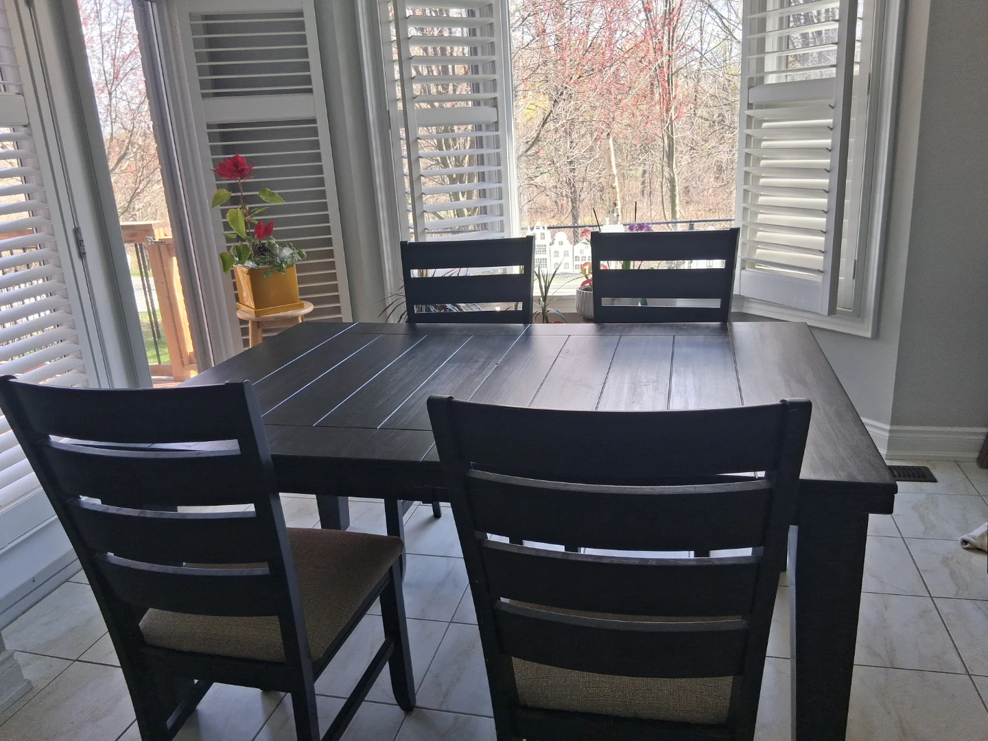 An Extendable Black Dining Table with 4 Padded Chairs