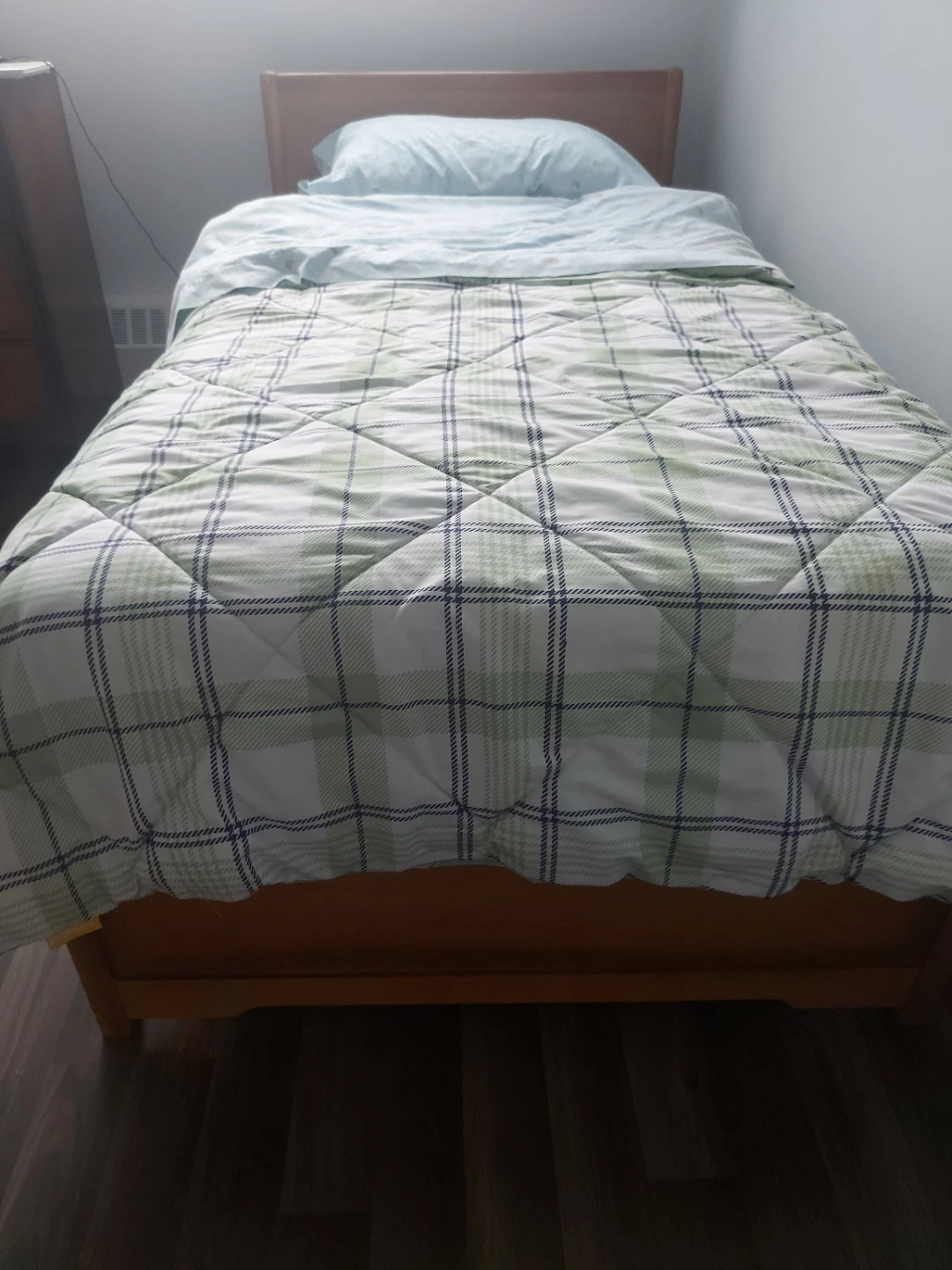 Wooden single bed frame with bedding