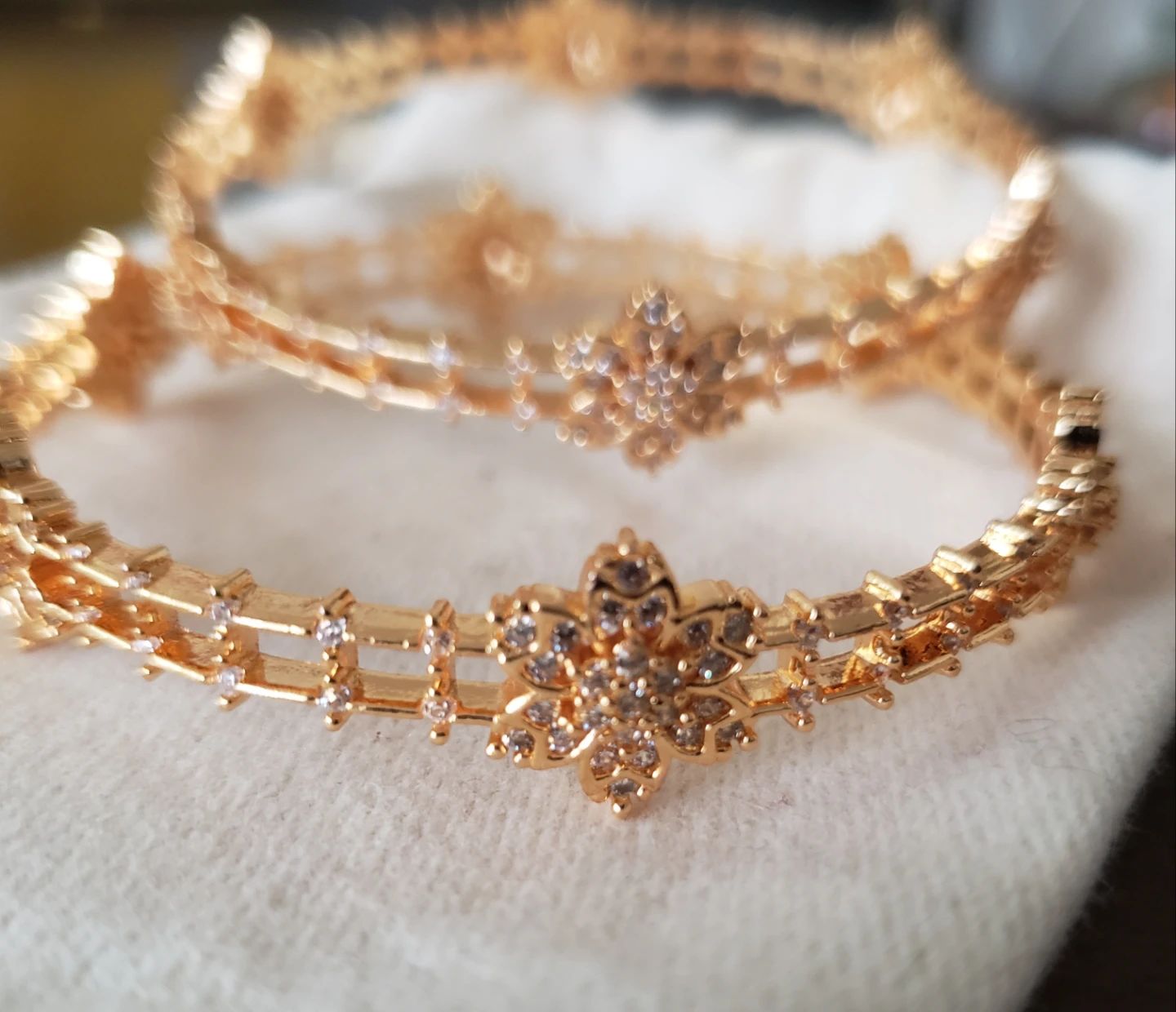 Gold-toned bangles with floral design and rhinestones