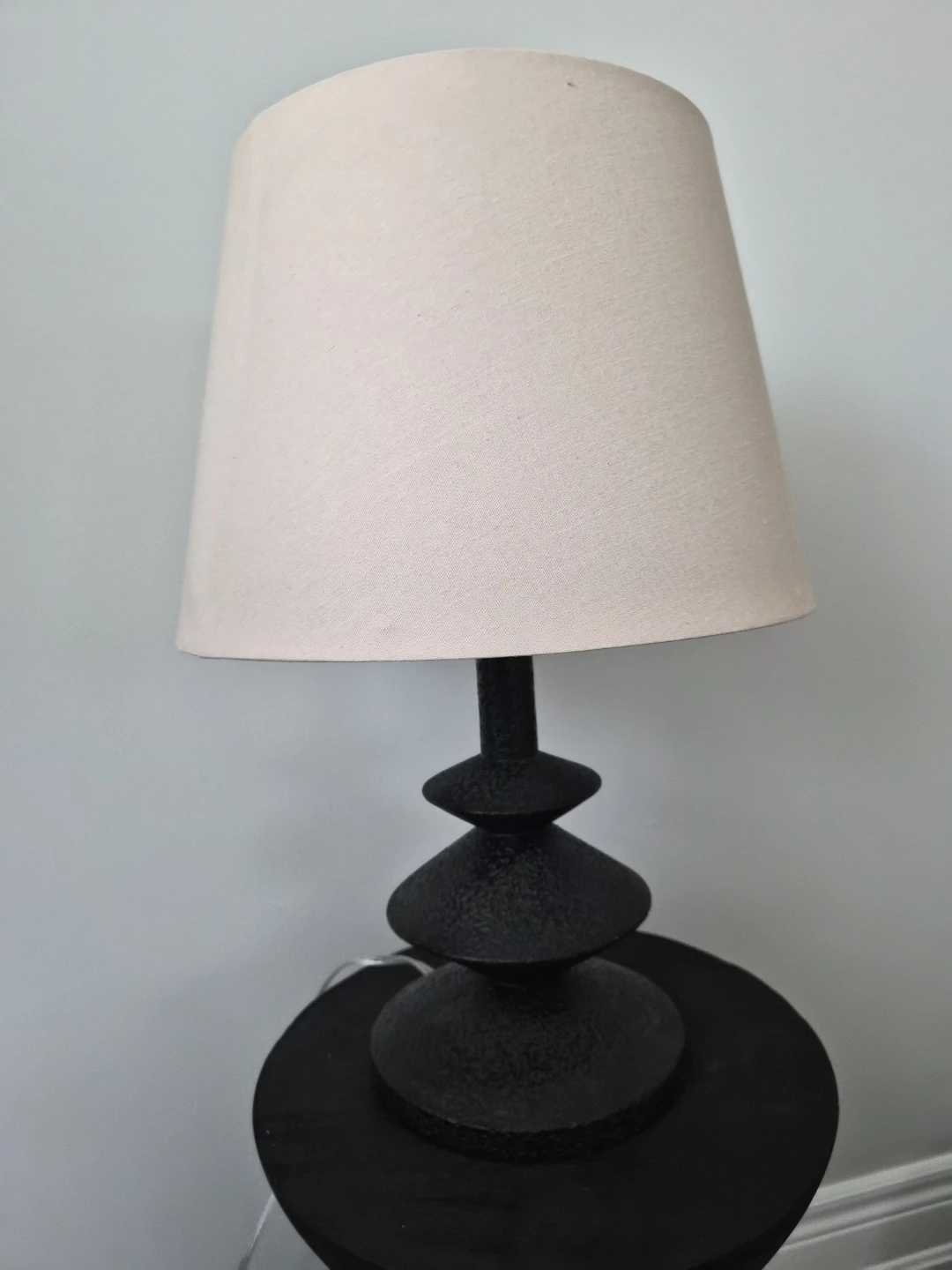 Black tiered table lamp with cream shade