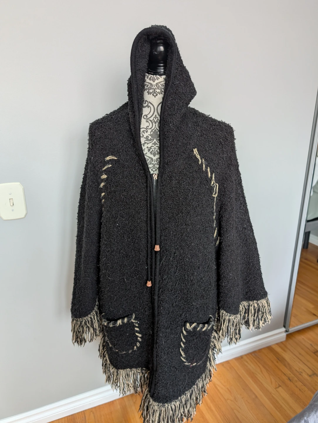 Black hooded poncho with fringe and pockets