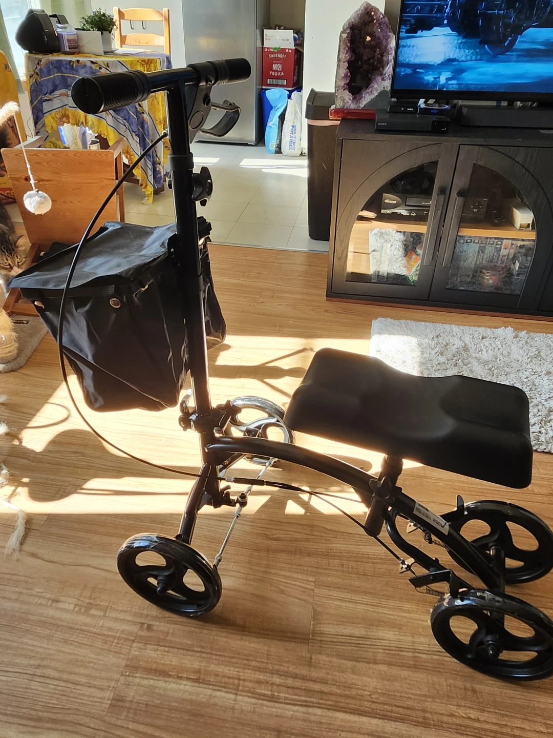 Three wheeled black Knee Scooter to assist with mobility