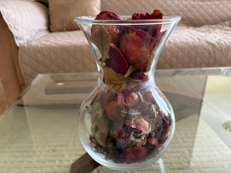 Glass vase with dried rose petals