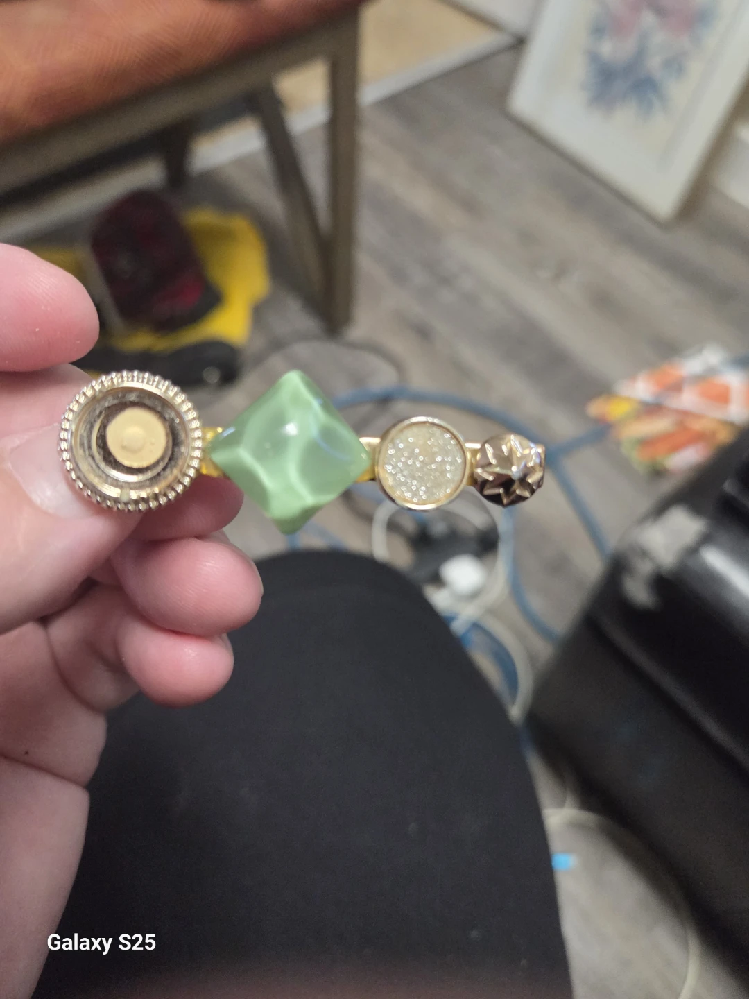 Gold-tone hair clip with green gem and glitter accents