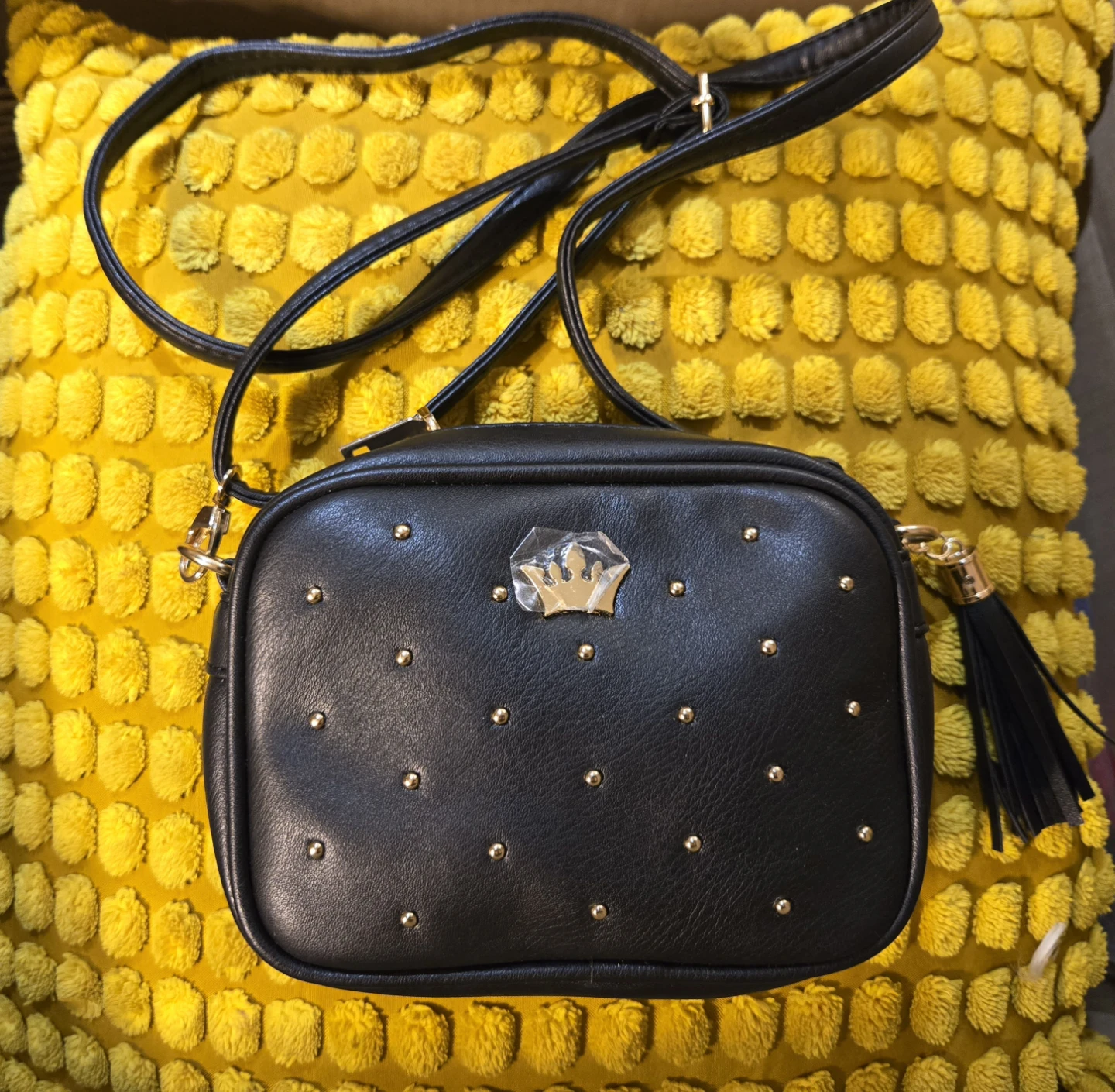 Black crossbody bag with gold studs and tassel