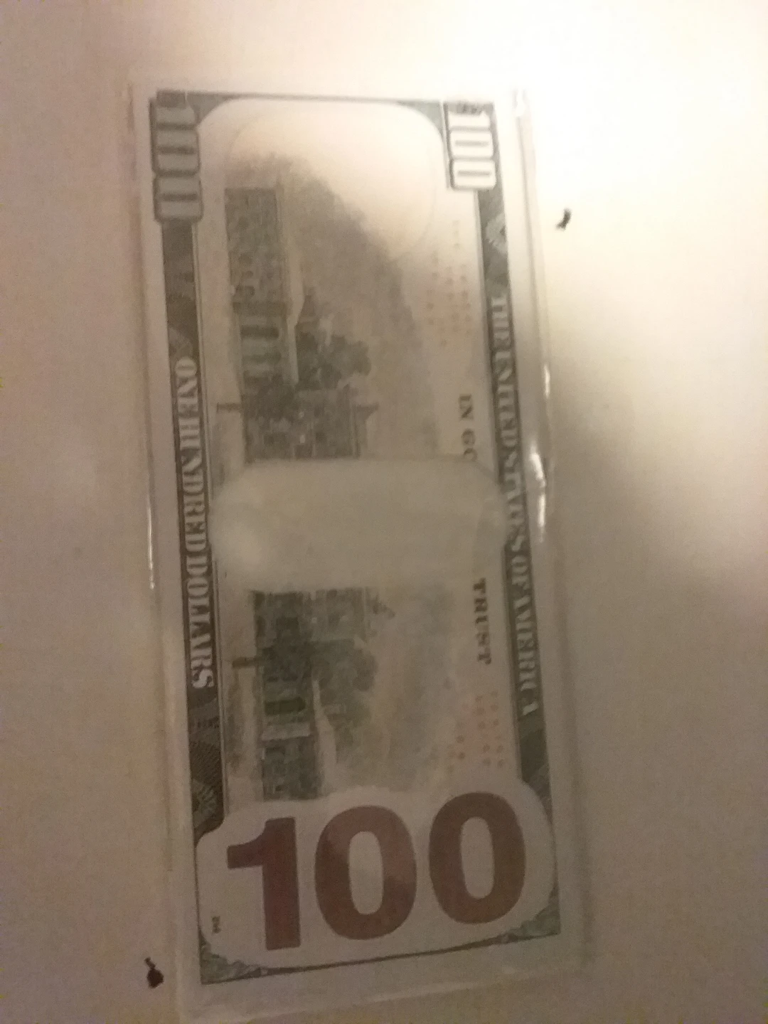 $100 bill in protective sleeve