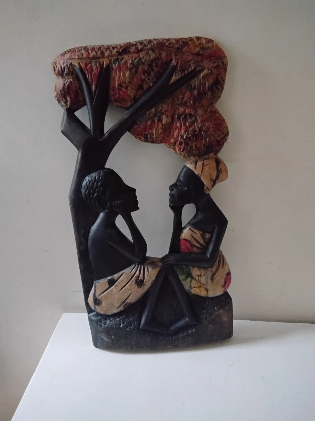 Carved wooden African couple under a tree