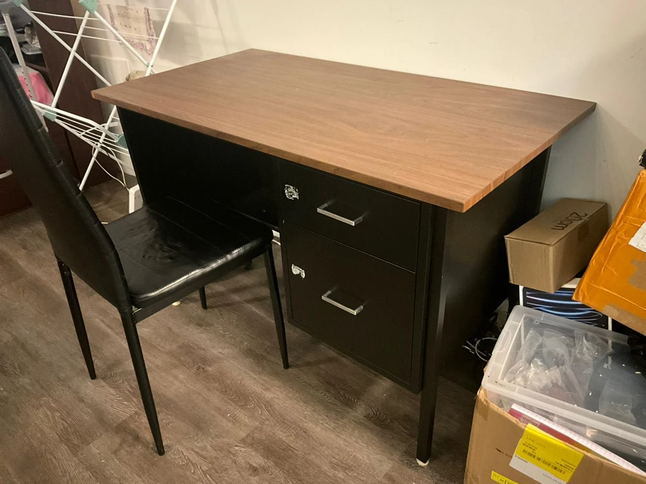 Wooden top desk and chair with black filing cabinet with drawers