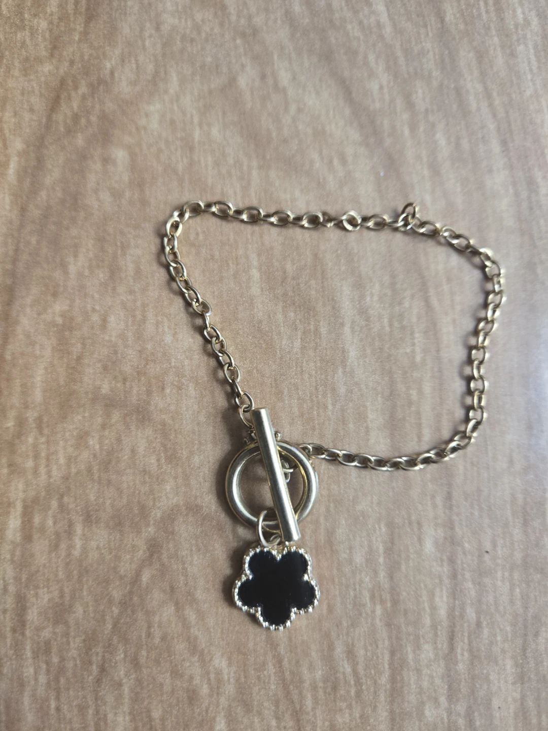 Gold-tone chain bracelet with black flower charm