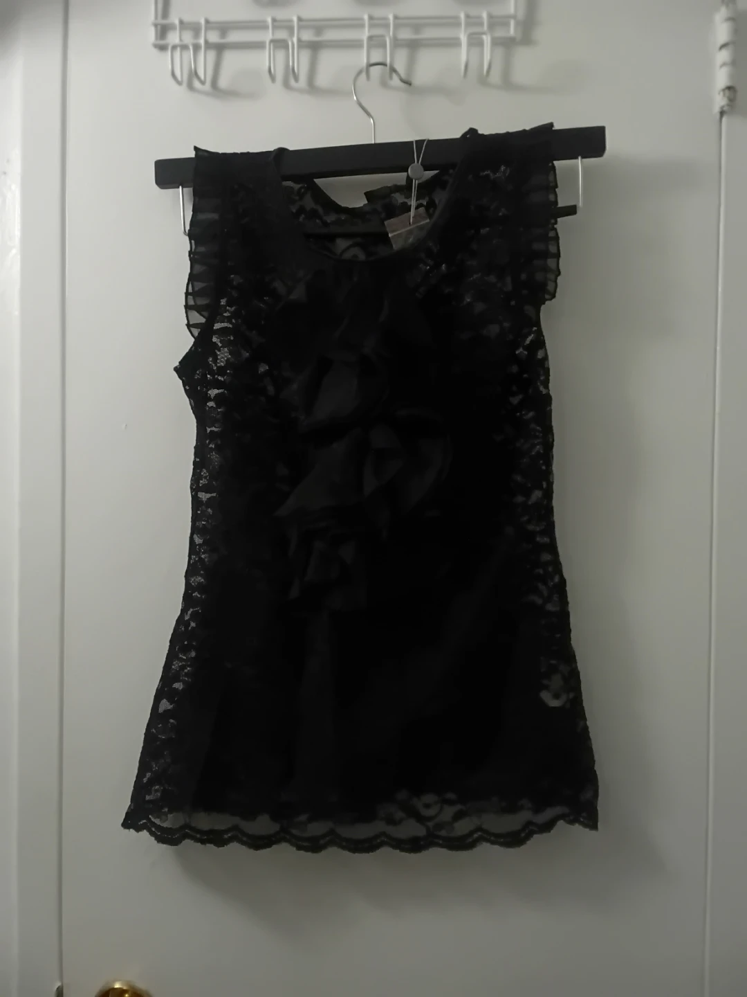 Black lace sleeveless top with ruffle detail.