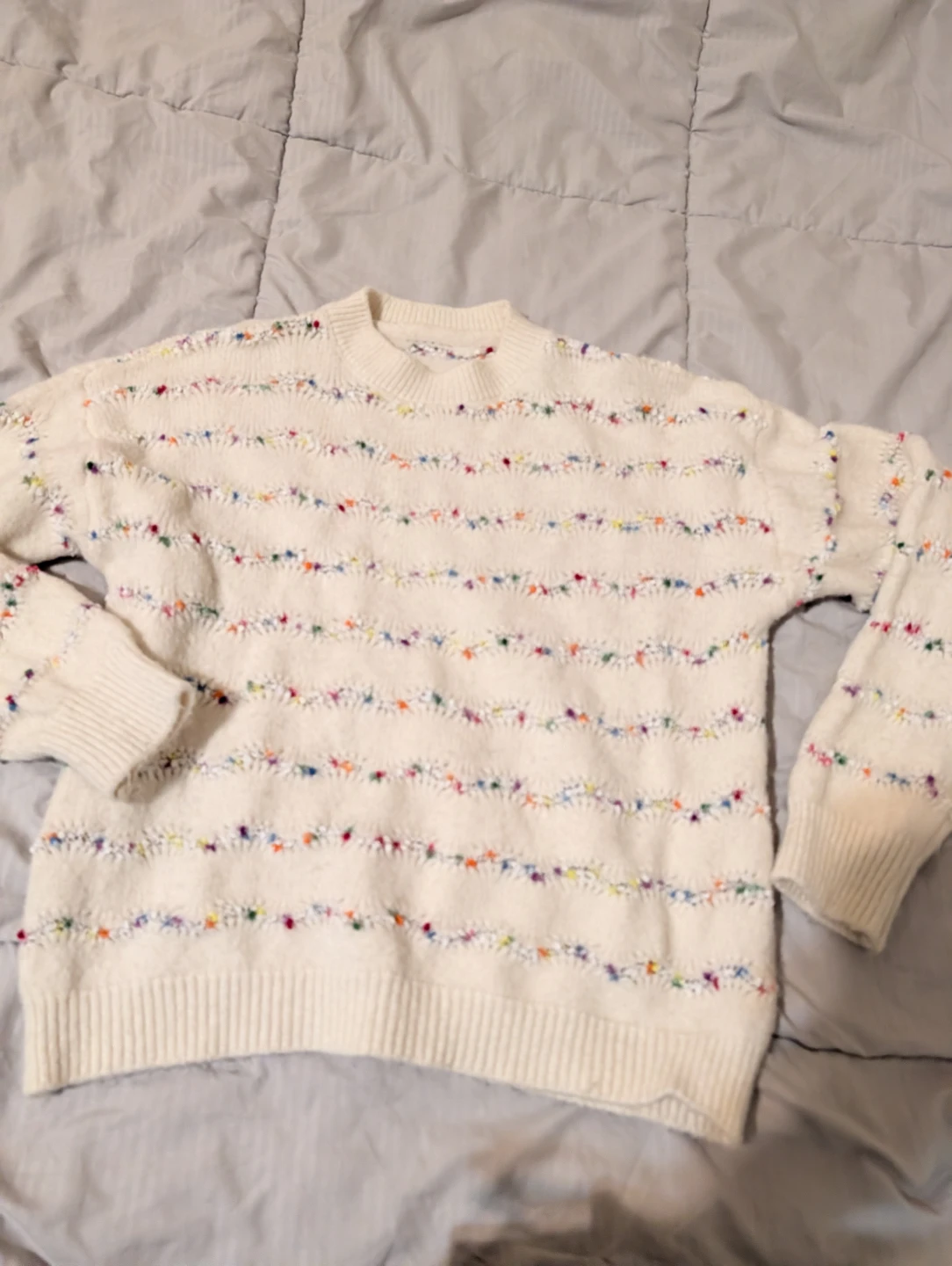 Cream sweater with colorful embroidered details