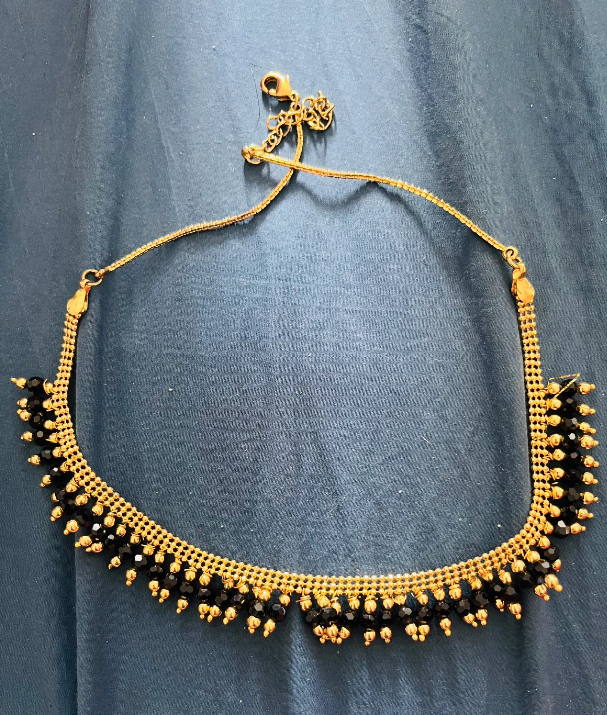 Gold tone necklace with black beads