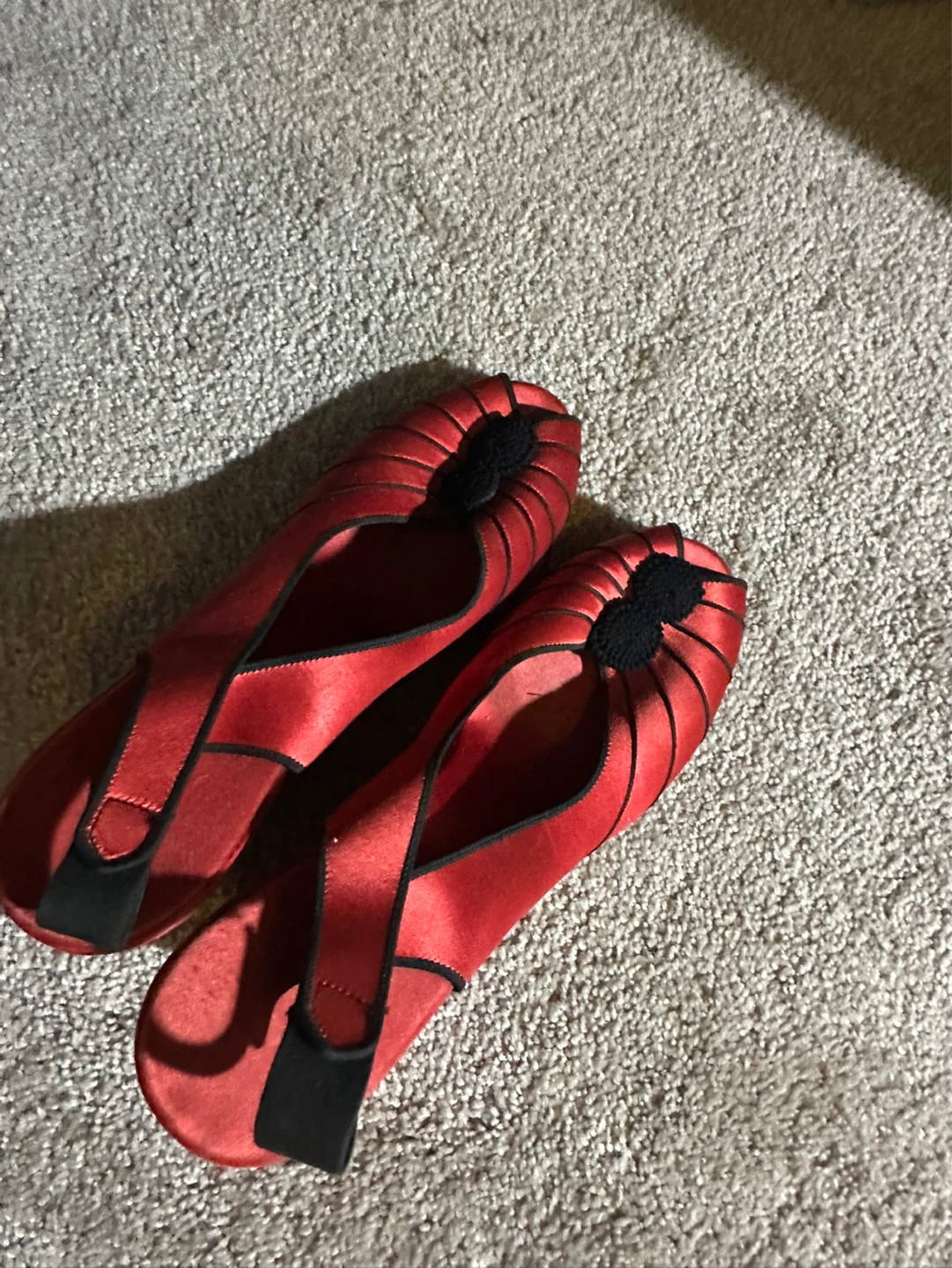 Red satin ballet flats with black accents