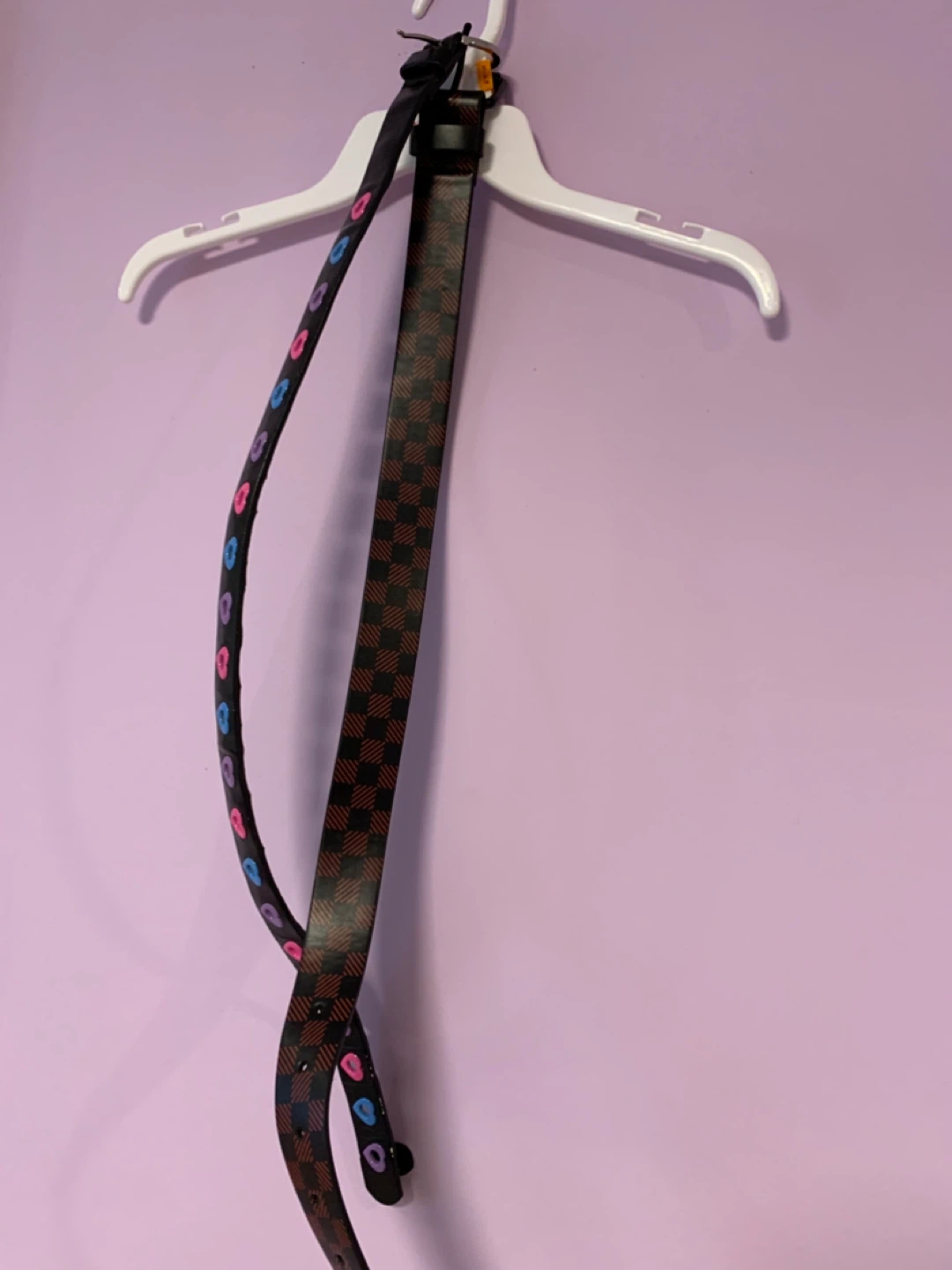 Two Belts: One Black Checkered, One with Colorful Hearts